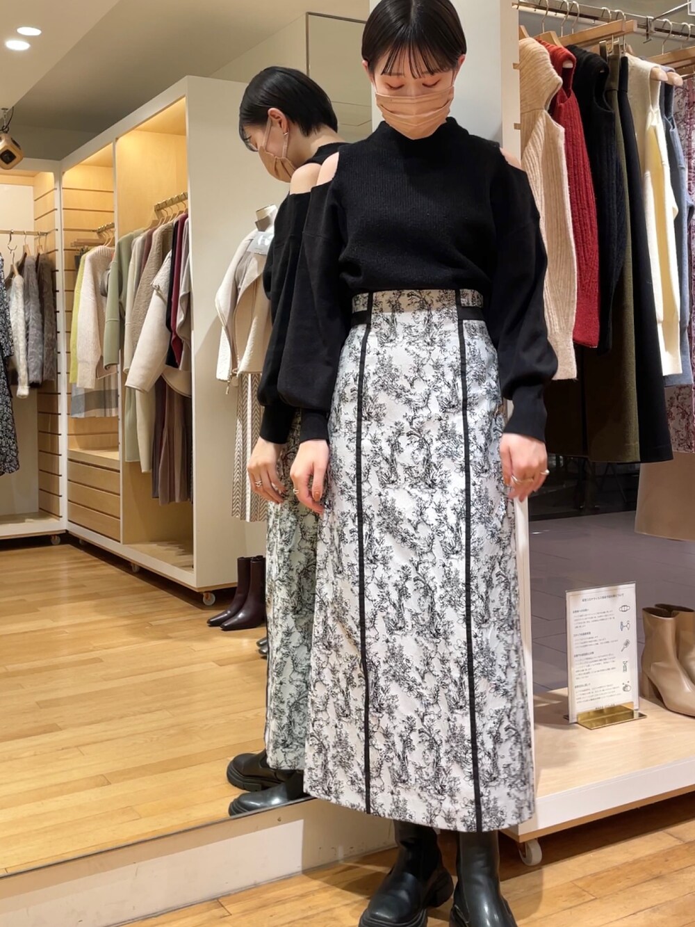 ブラック系のニット/セーター、ブラック系のスカートを着用したレディースの冬コーディネートの2枚目の写真