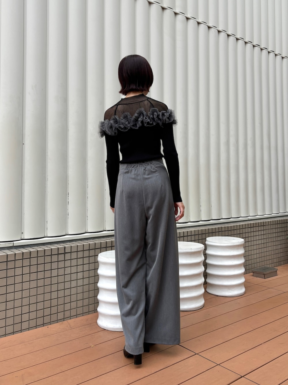 グレー系のその他パンツ、ブラック系のニット/セーター、ブラック系のブーツを着用したレディースの秋コーディネートの3枚目の写真
