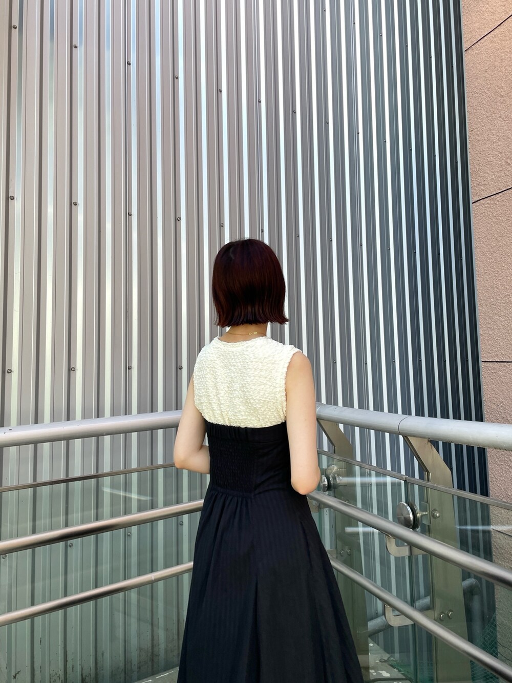 ブラック系のサンダル、ブラック系のワンピースを着用したレディースの夏コーディネートの7枚目の写真