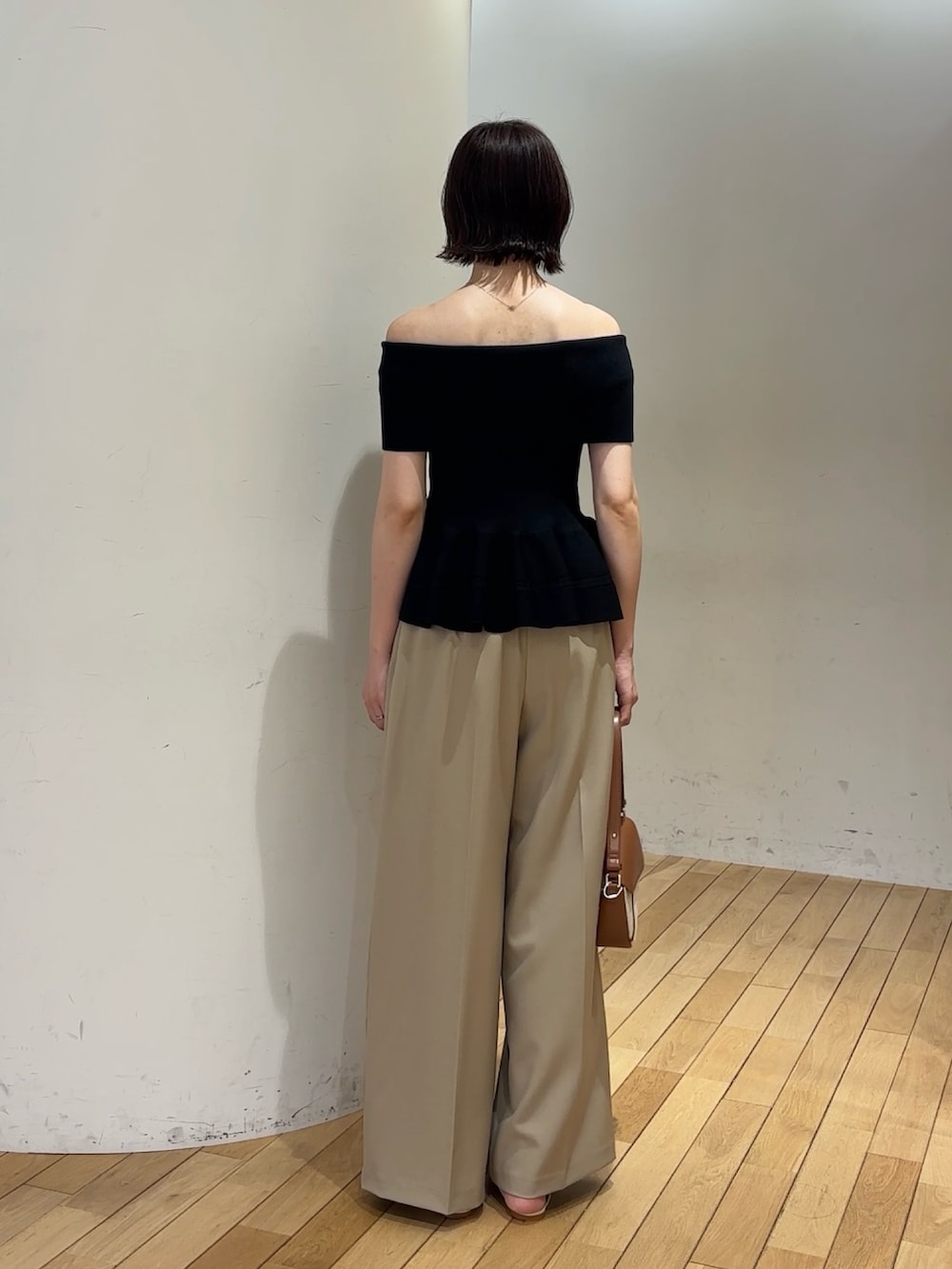ベージュ系のその他パンツ、ホワイト系のサンダル、ブラウン系のハンドバッグを着用したレディースの夏コーディネートの4枚目の写真
