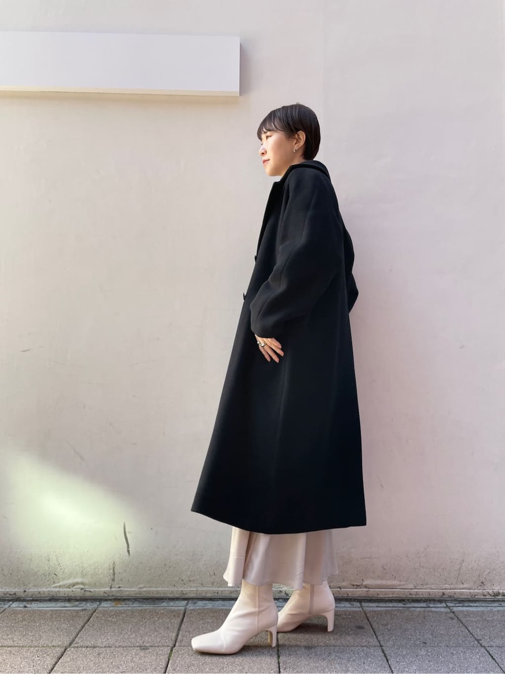 ホワイト系のその他シューズ、グレー系のスカート、ブラック系のその他アウターを着用したレディースの冬コーディネートの7枚目の写真