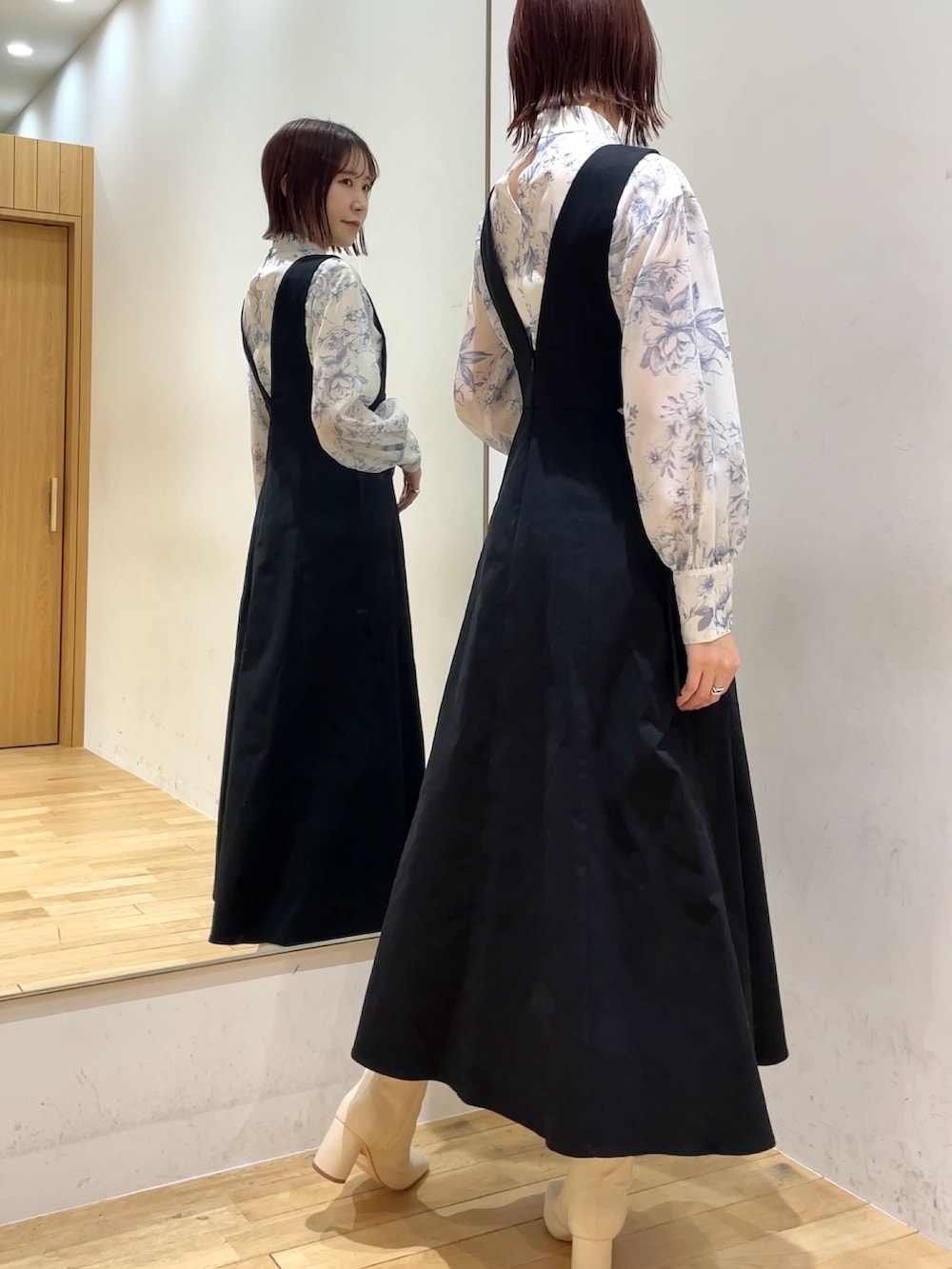 ホワイト系のブーツ、ブルー系のシャツ/ブラウス、ブラック系のジャンパースカートを着用したレディースの冬コーディネートの2枚目の写真