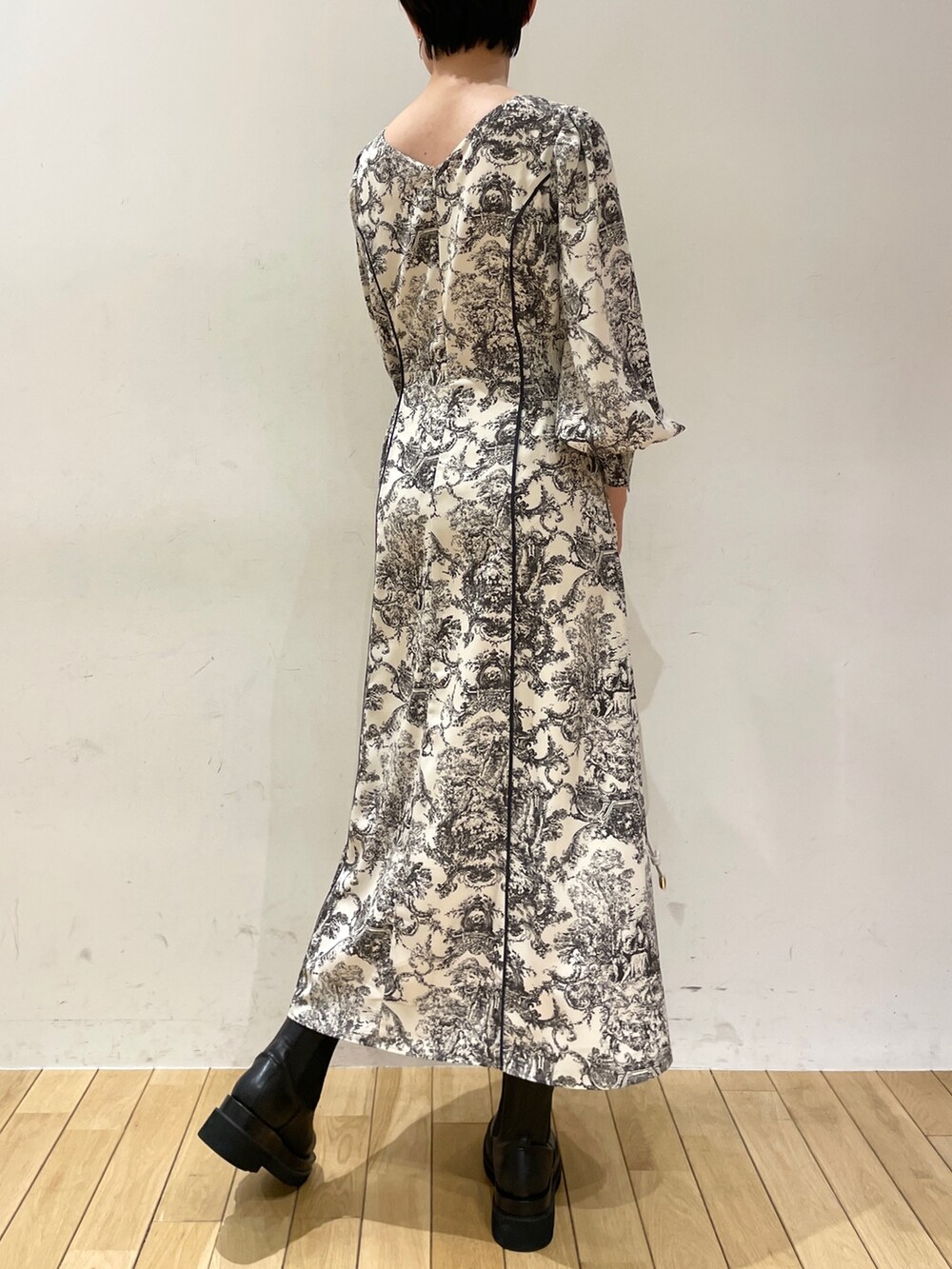 ブラック系のダウンジャケット/コート、ホワイト系のワンピース、ブラック系のブーツを着用したレディースの冬コーディネートの8枚目の写真