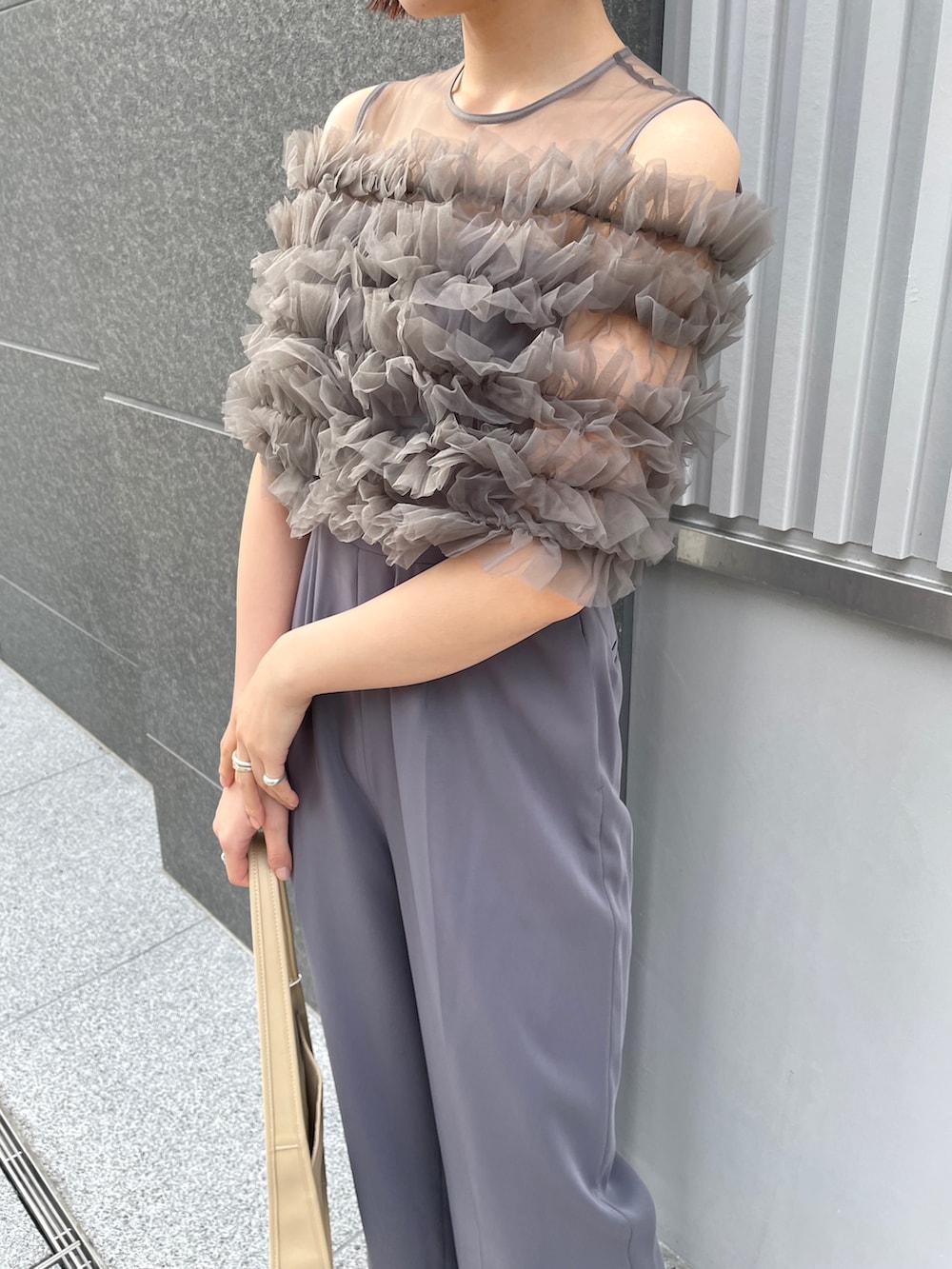 その他のパンプス、グレー系のパンツドレス、ベージュ系のハンドバッグを着用したレディースの春コーディネートの4枚目の写真