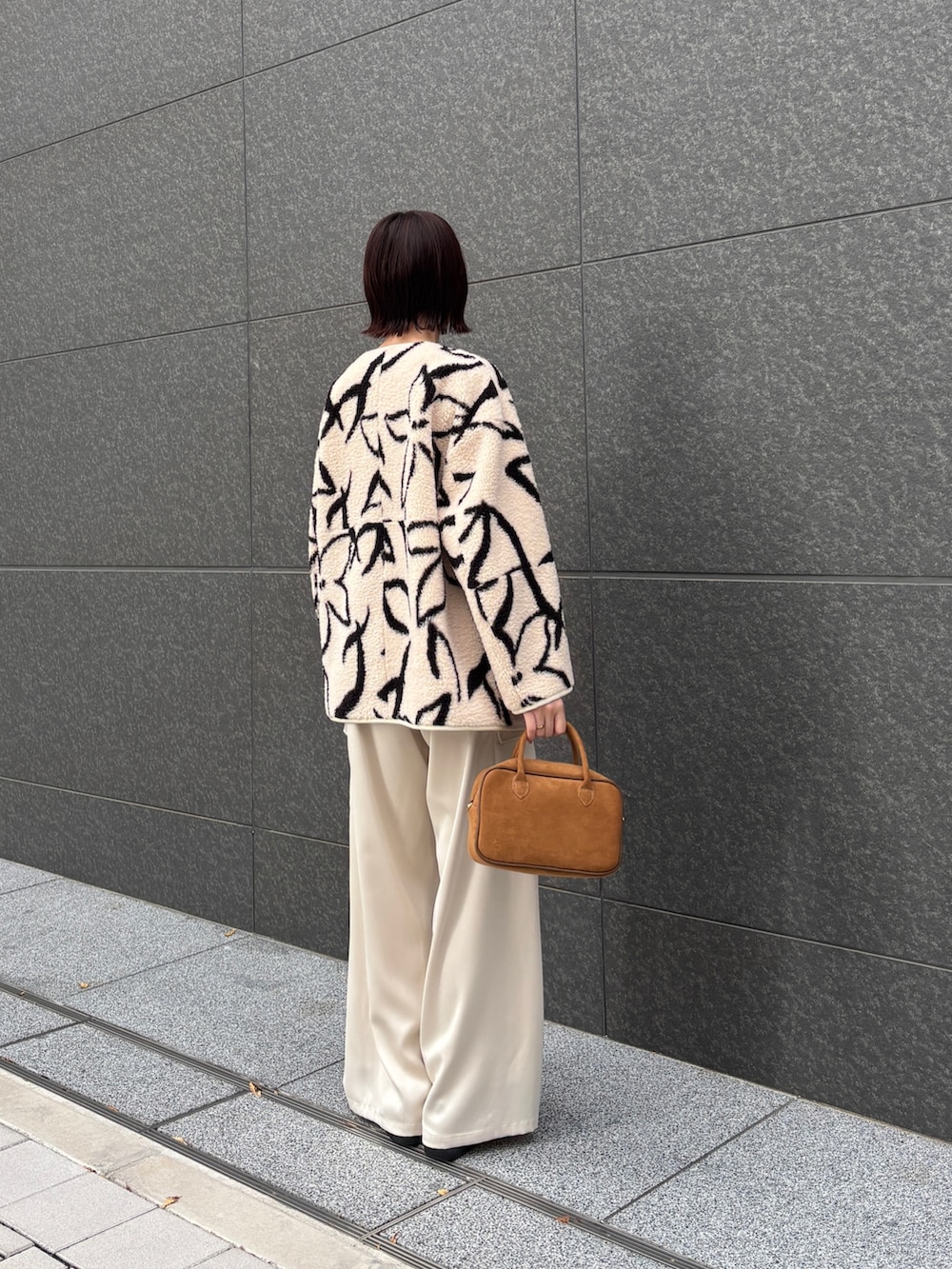 ホワイト系のブルゾン、ホワイト系のニット/セーター、ホワイト系のカーゴパンツを着用したレディースの冬コーディネートの3枚目の写真