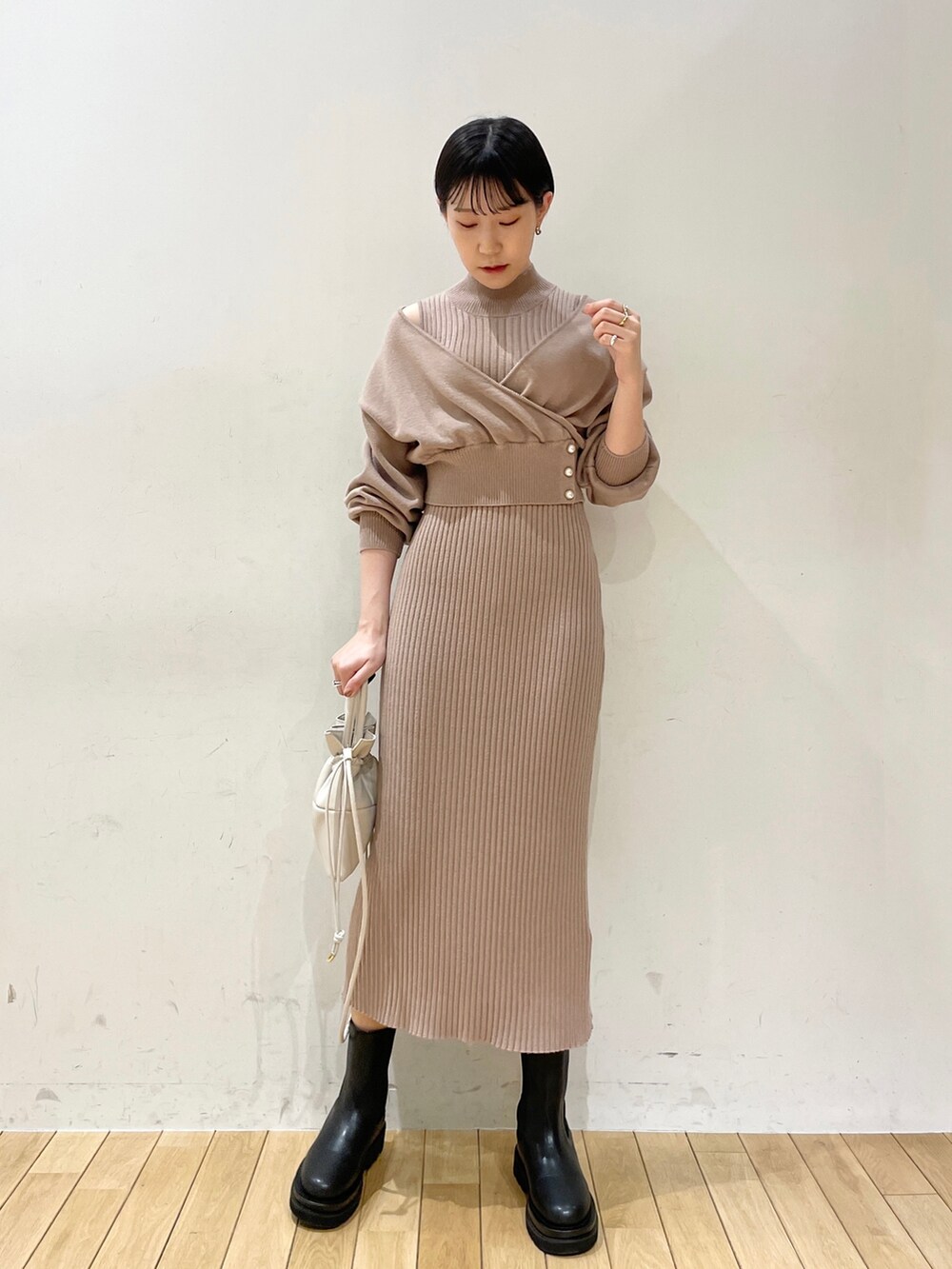 ホワイト系のカーディガン/ボレロ、ベージュ系のワンピース、ホワイト系のハンドバッグを着用したレディースの冬コーディネートの8枚目の写真