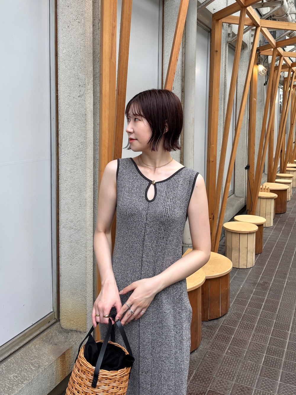 グレー系のワンピース、ブラウン系のハンドバッグを着用したレディースの夏コーディネートの5枚目の写真