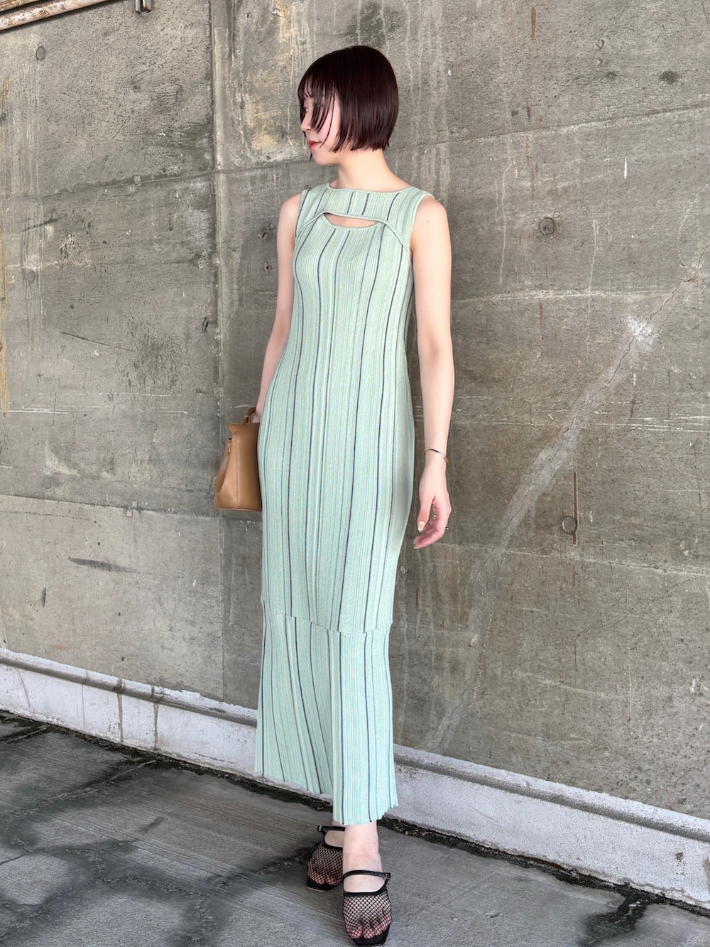 グリーン系のワンピース、ホワイト系のテーラードジャケット、ブラック系のサンダルを着用したレディースの春コーディネートの6枚目の写真