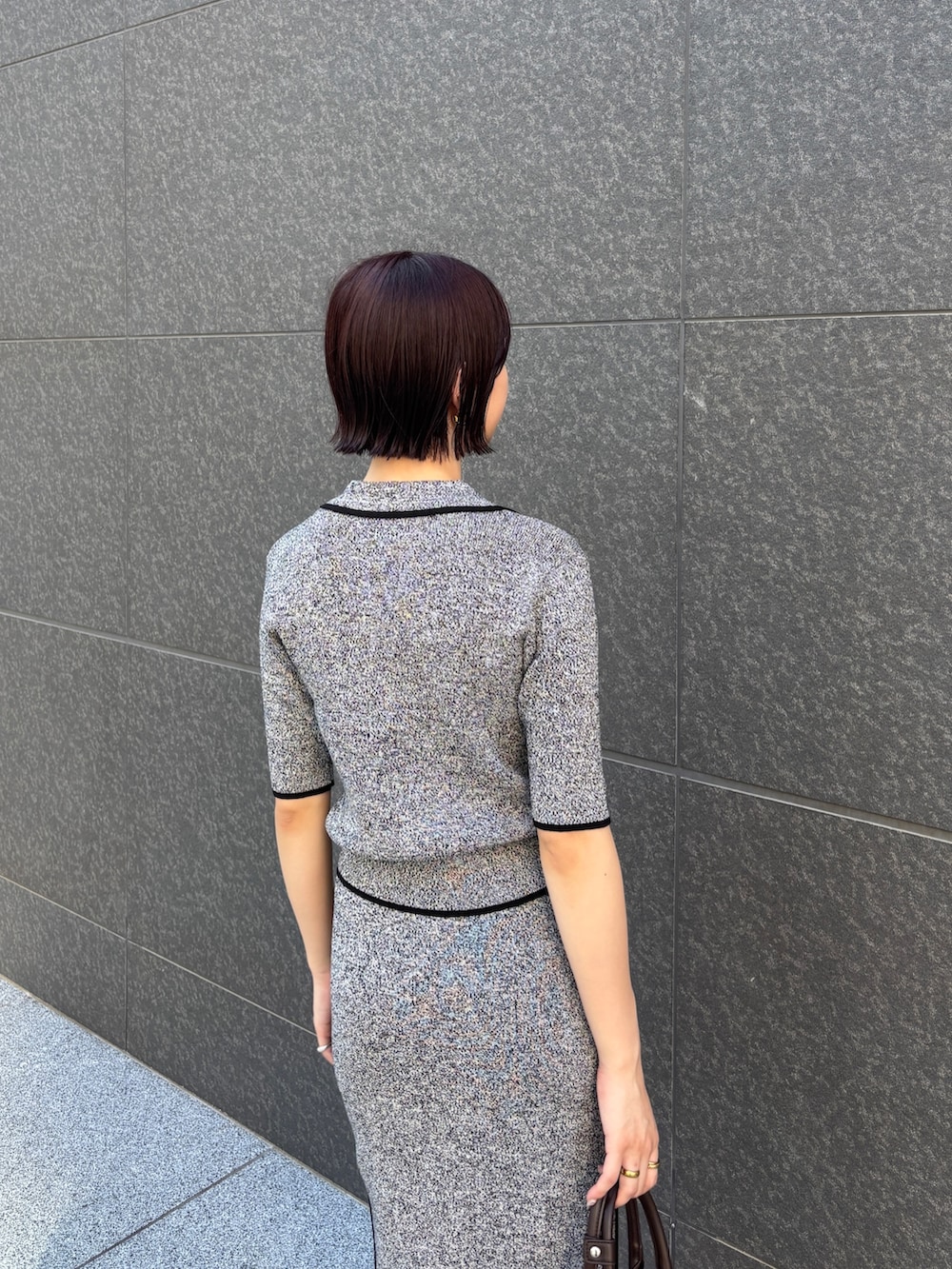 ブラック系のワンピース、ブラウン系のボストンバッグ、ブラウン系のパンプスを着用したレディースの夏コーディネートの5枚目の写真