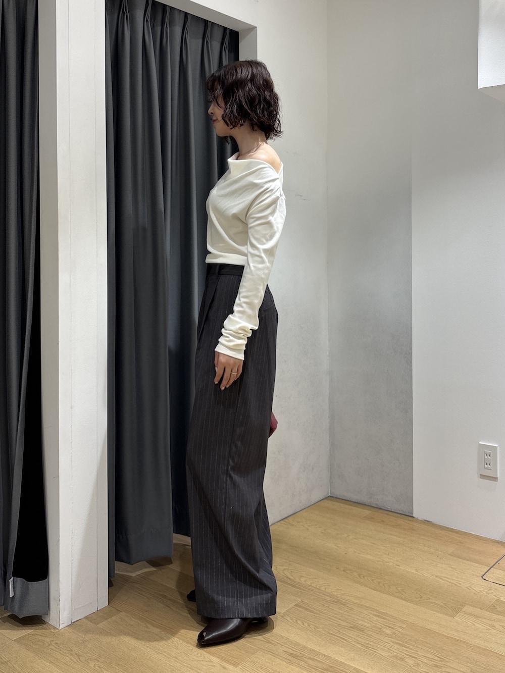 グレー系のその他パンツ、ホワイト系のニット/セーター、レッド系のハンドバッグを着用したレディースの秋コーディネートの8枚目の写真