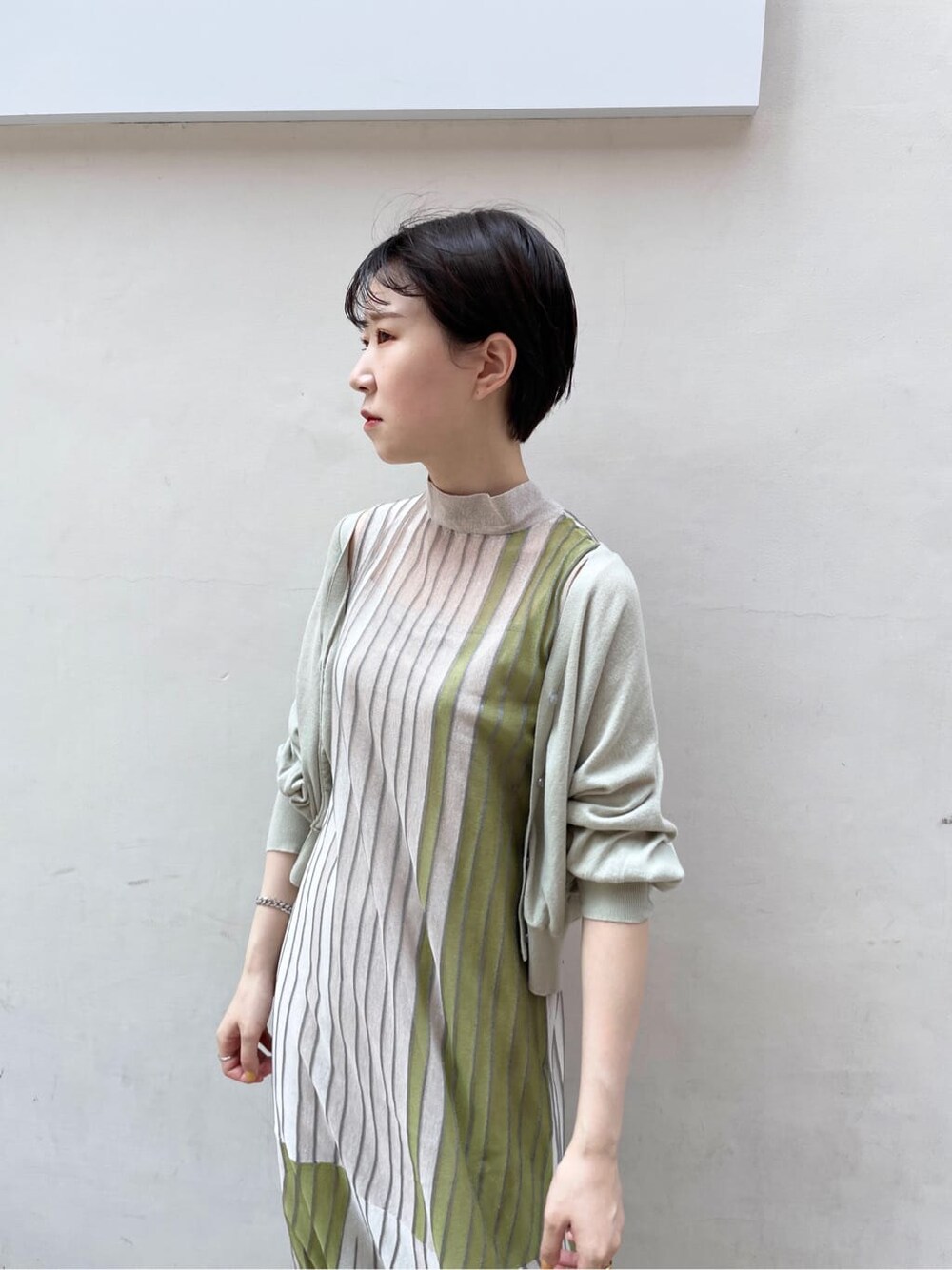 グリーン系のワンピース、グリーン系のカーディガン/ボレロ、ベージュ系のサンダルを着用したレディースの夏コーディネートの7枚目の写真