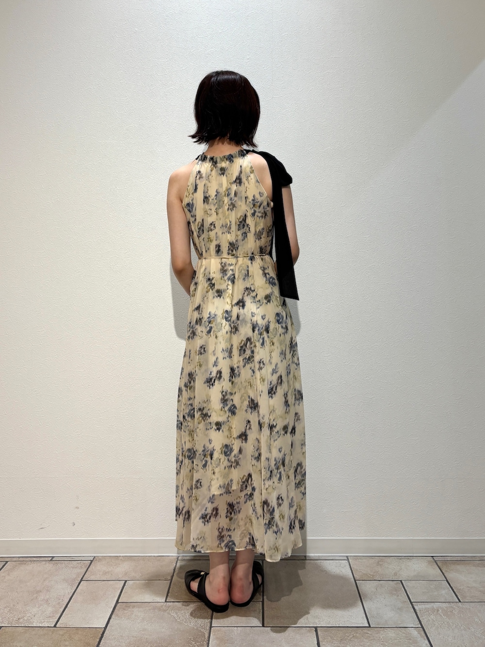イエロー系のワンピース、ブラウン系のサンダル、ブラウン系のハンドバッグを着用したレディースの夏コーディネートの6枚目の写真