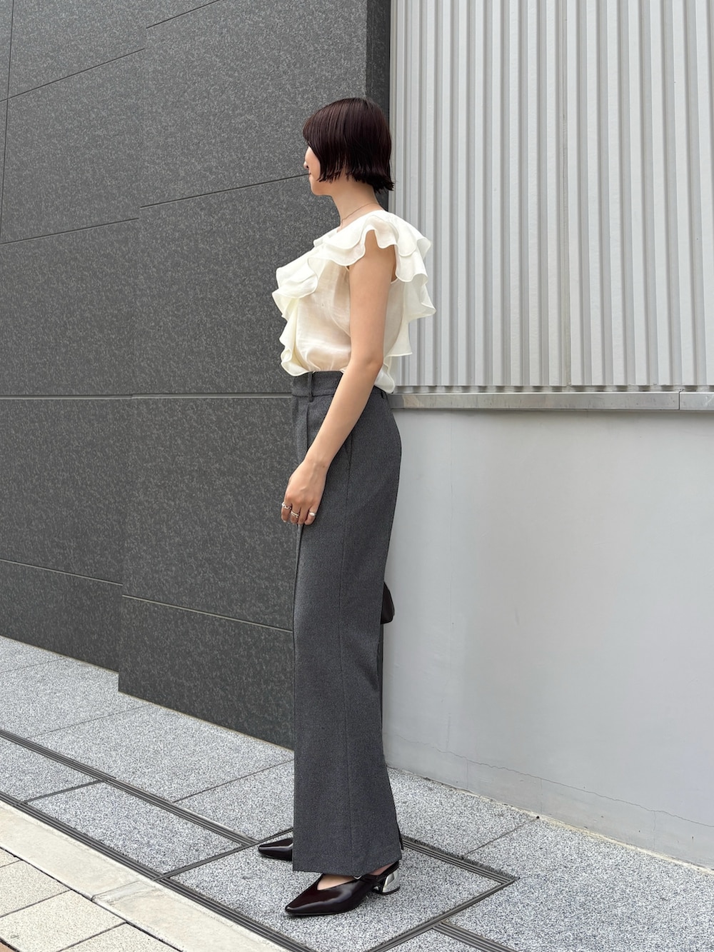 グレー系のその他パンツ、ホワイト系のシャツ/ブラウス、ブラウン系のボストンバッグを着用したレディースの夏コーディネートの2枚目の写真
