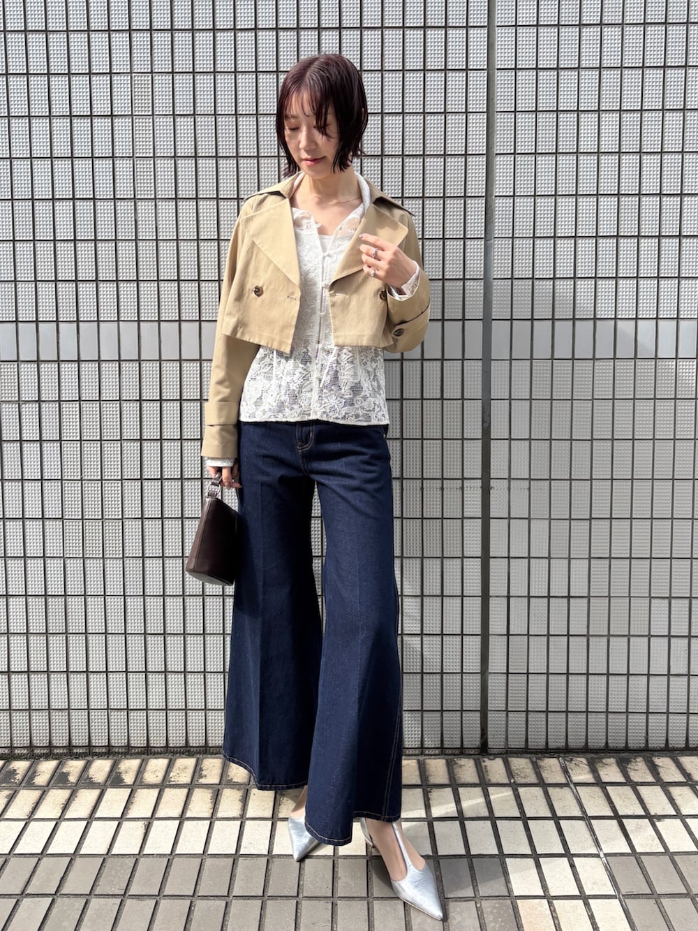 ブルー系のデニムパンツ、ベージュ系のトレンチコート、ホワイト系のシャツ/ブラウスを着用したレディースの冬コーディネートの3枚目の写真