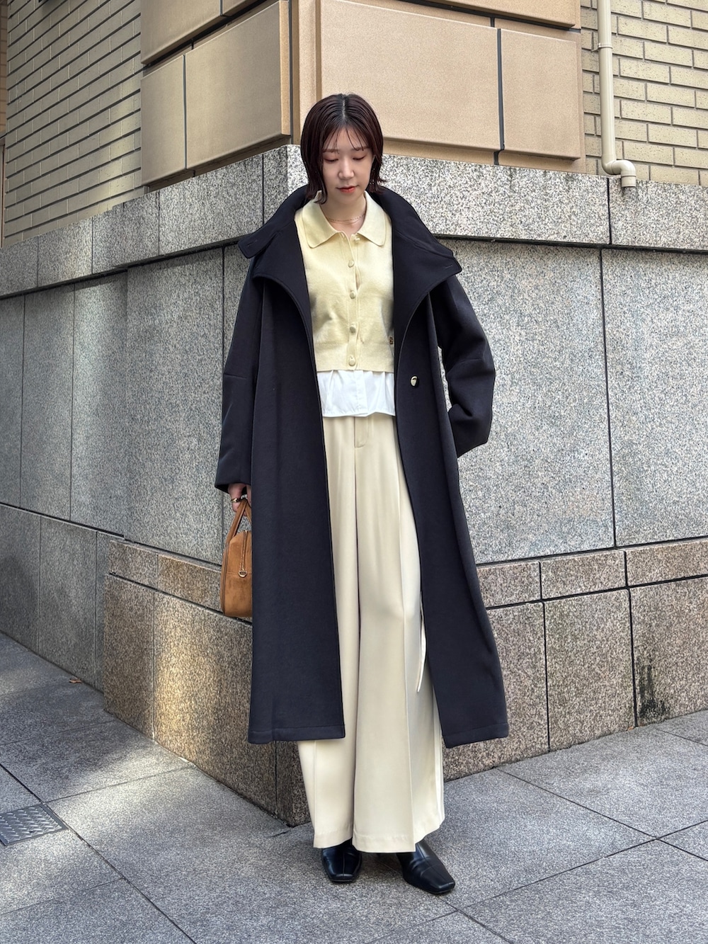 ベージュ系のその他パンツ、イエロー系のカーディガン/ボレロ、イエロー系のハンドバッグを着用したレディースの秋コーディネートの2枚目の写真