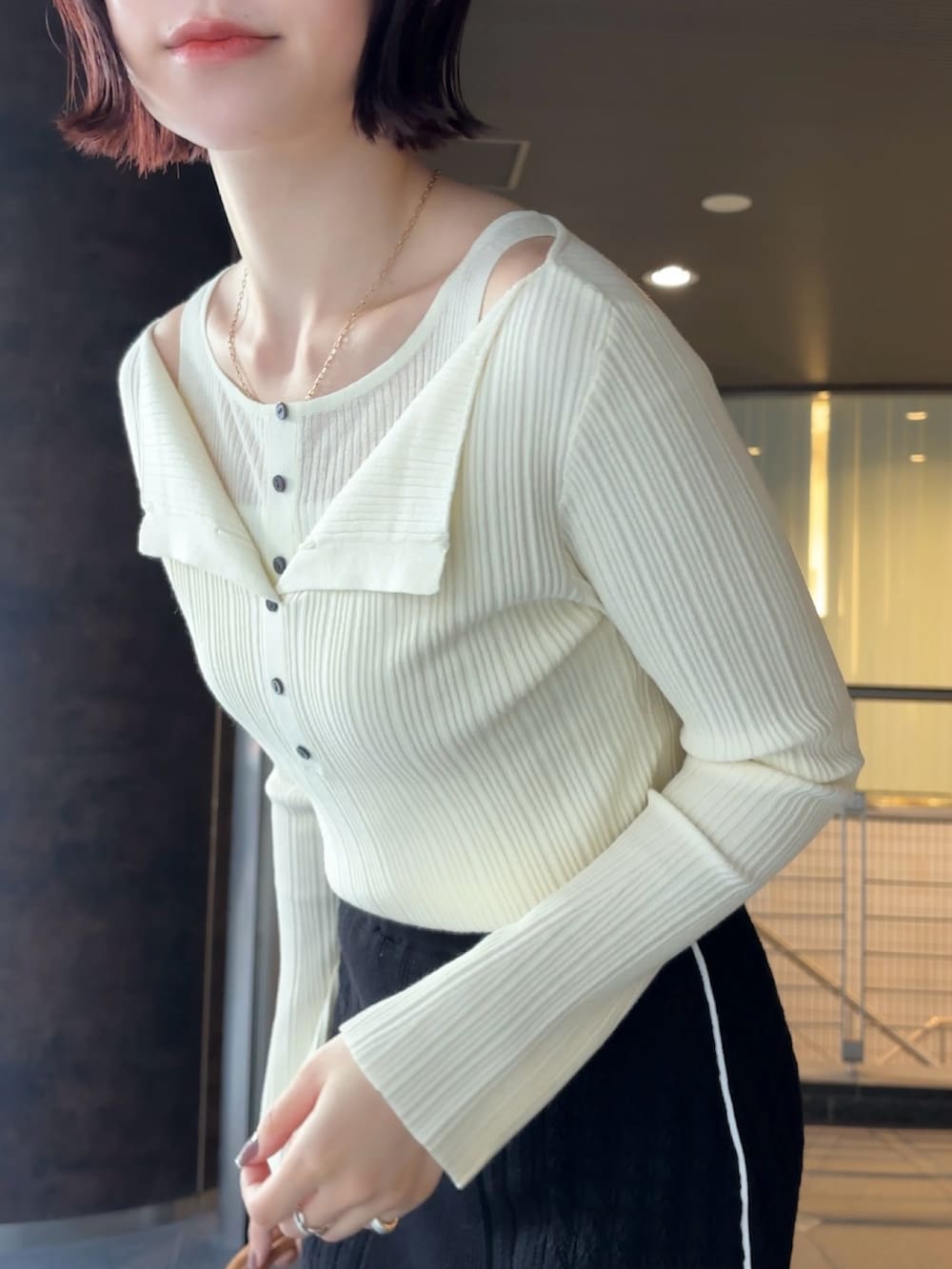 イエロー系のハンドバッグ、ブラウン系のブーツ、ホワイト系のニット/セーターを着用したレディースの冬コーディネートの5枚目の写真