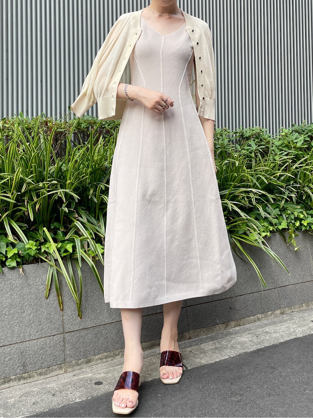 ブラウン系のサンダル、ベージュ系のワンピース、ホワイト系のカーディガン/ボレロを着用したレディースの夏コーディネートの2枚目の写真