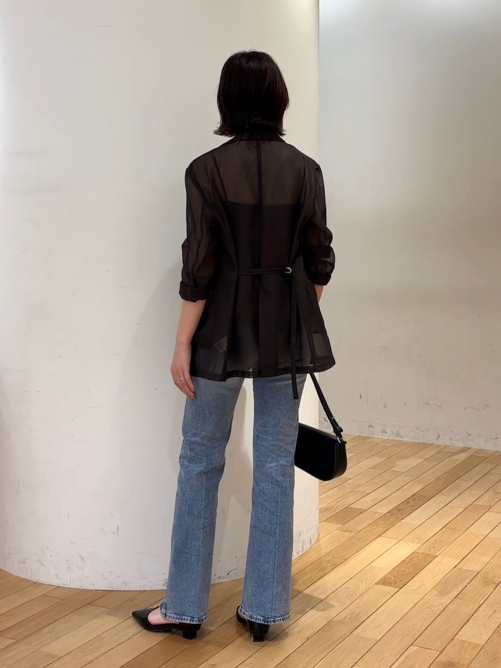 ブルー系のデニムパンツ、ブラック系のハンドバッグ、ブラック系のパンプスを着用したレディースの夏コーディネートの6枚目の写真