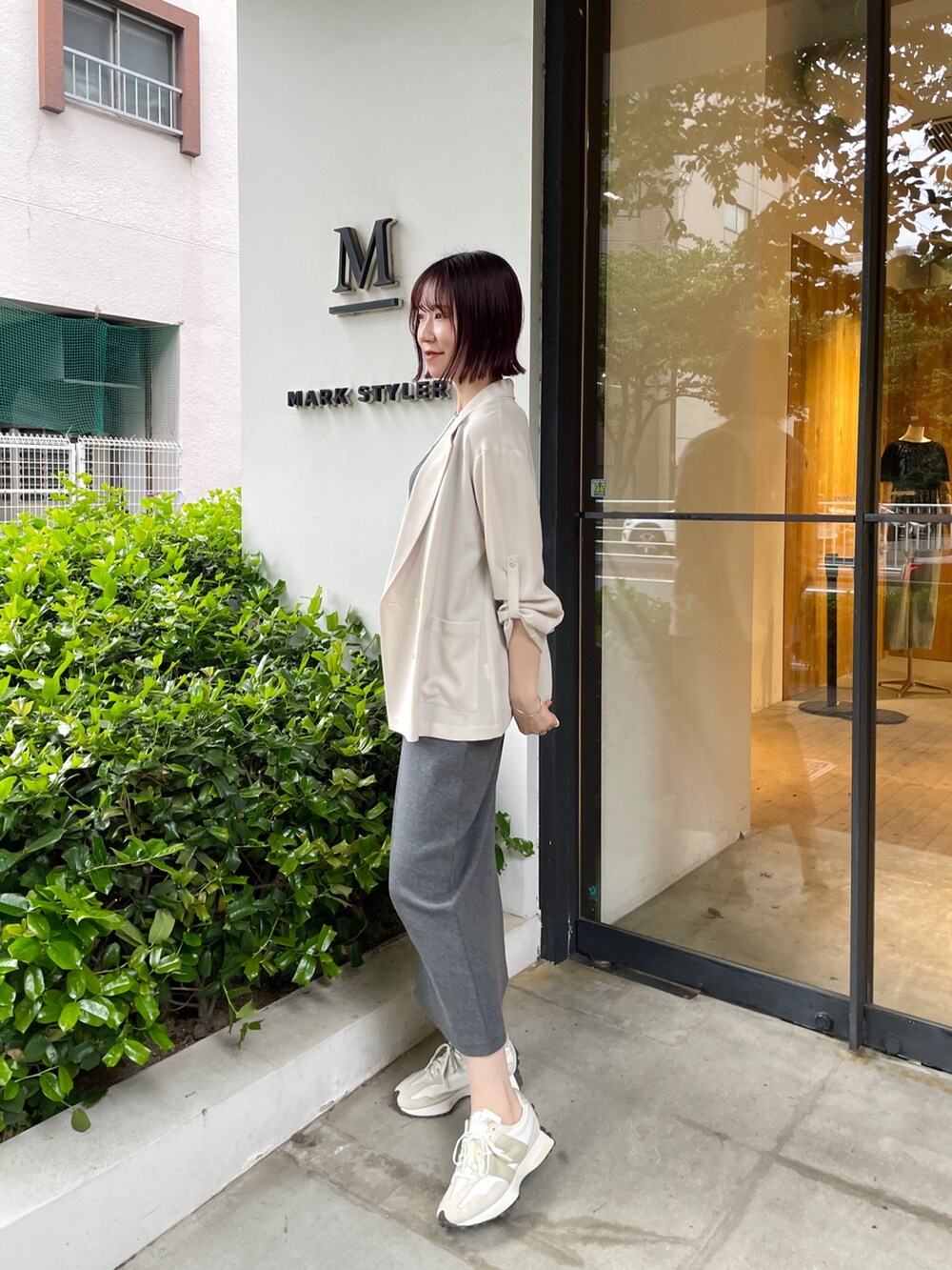 グレー系のワンピース、ベージュ系のテーラードジャケットを着用したレディースの春コーディネートの3枚目の写真