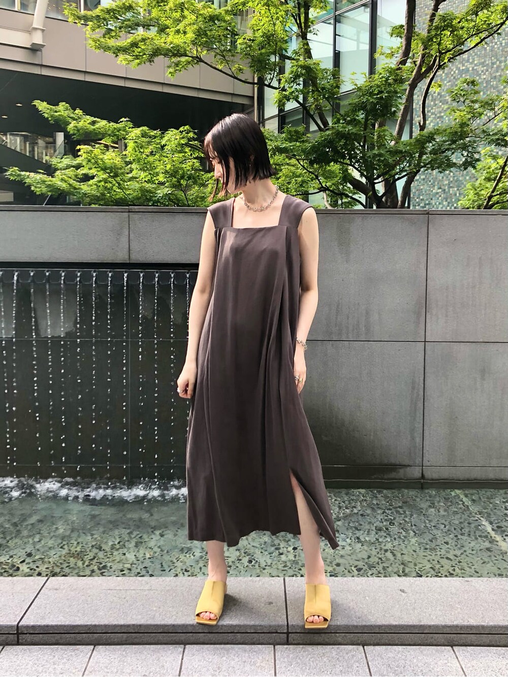 イエロー系のサンダル、グレー系のワンピース、シルバー系のネックレスを着用したレディースの夏コーディネートの2枚目の写真