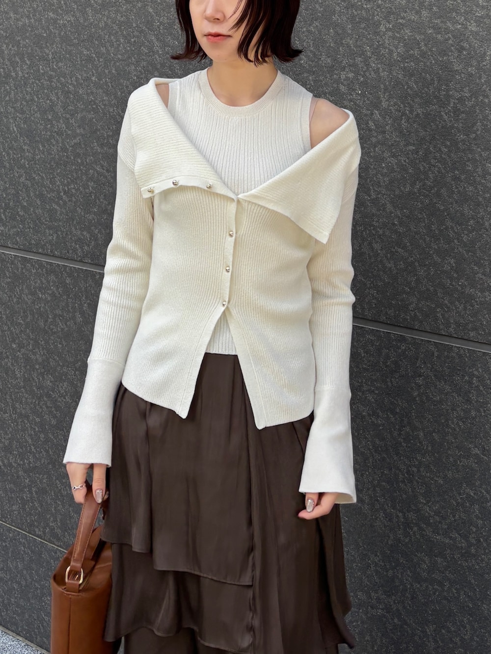 ホワイト系のムートンコート、ホワイト系のアンサンブル、イエロー系のハンドバッグを着用したレディースの冬コーディネートの7枚目の写真