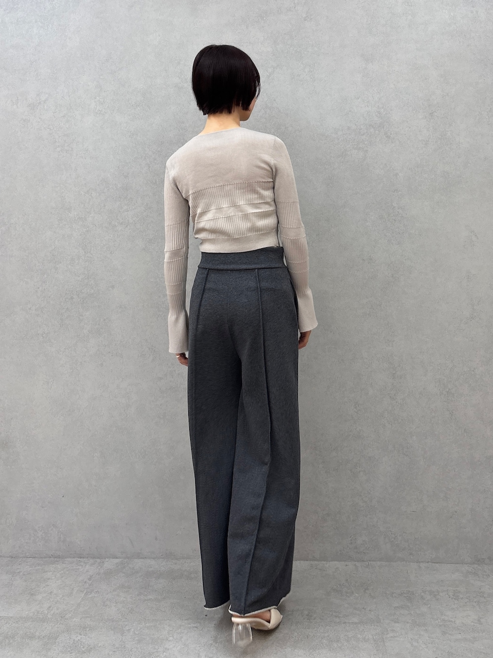 グレー系のスウェットパンツ、グレー系のカーディガン/ボレロ、ホワイト系のチューブトップを着用したレディースの春コーディネートの4枚目の写真