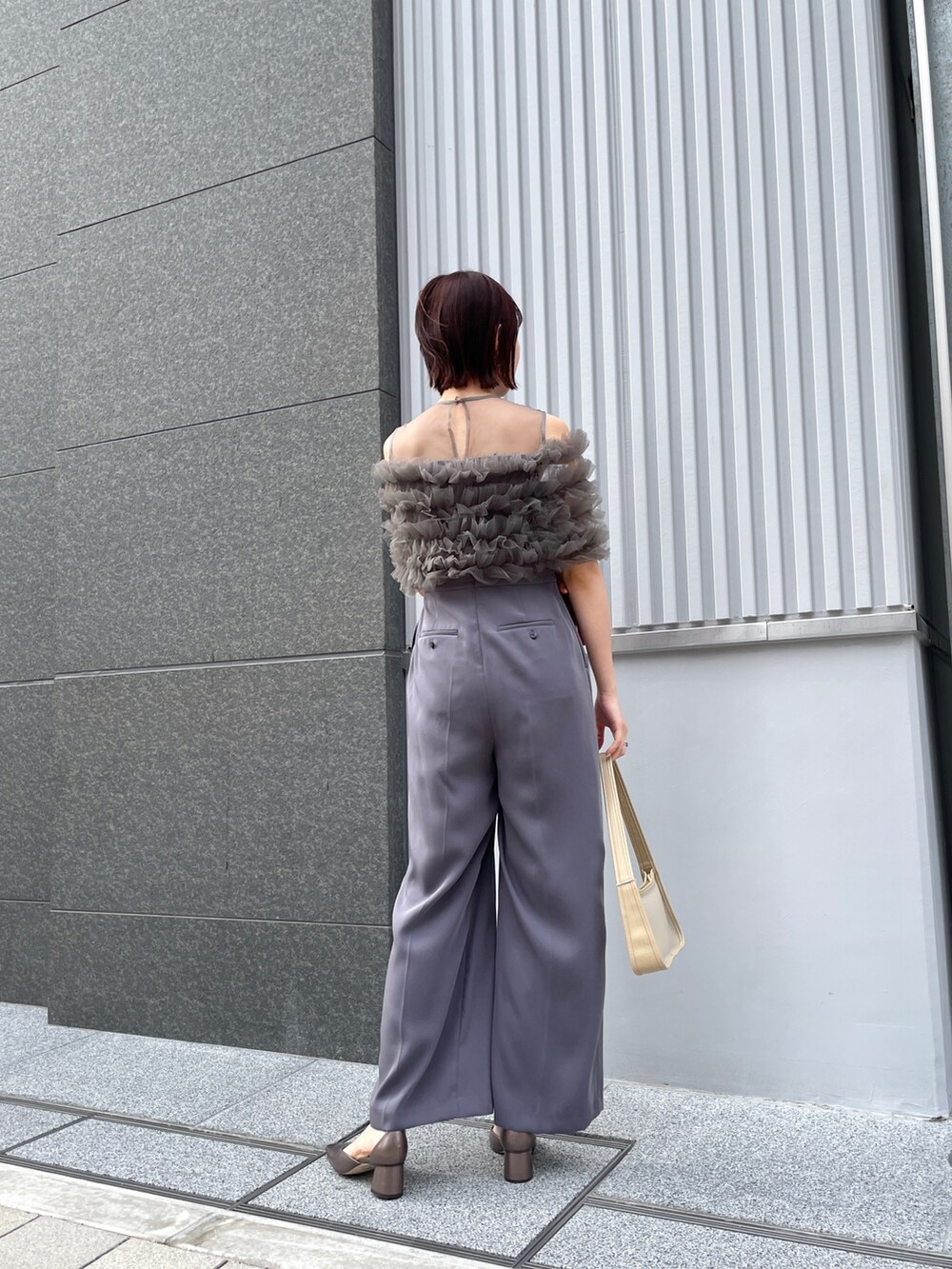 その他のパンプス、グレー系のパンツドレス、ベージュ系のハンドバッグを着用したレディースの春コーディネートの3枚目の写真