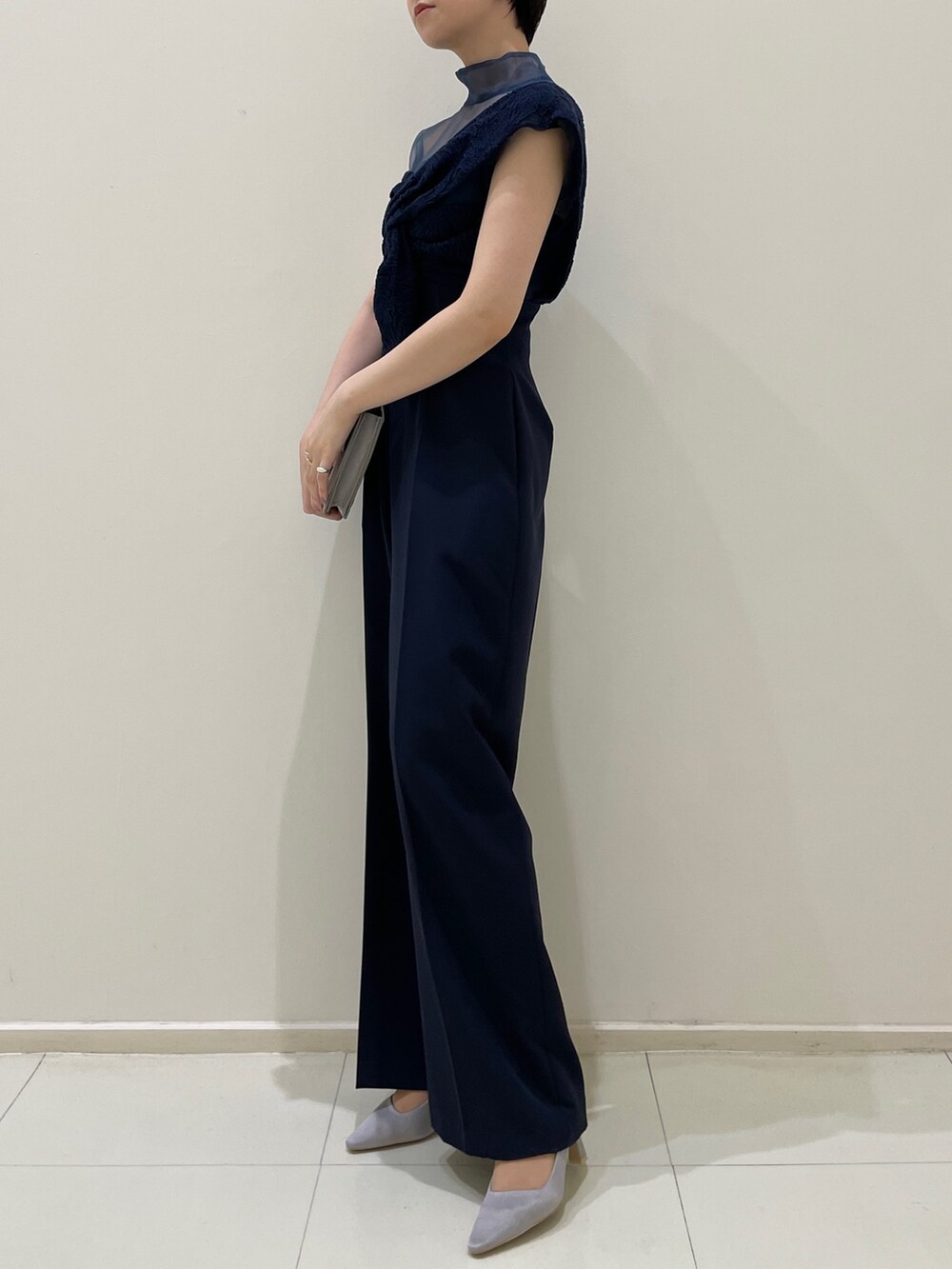 ブルー系のパンツドレス、グレー系のクラッチバッグ、グレー系のパンプスを着用したレディースの冬コーディネートの5枚目の写真