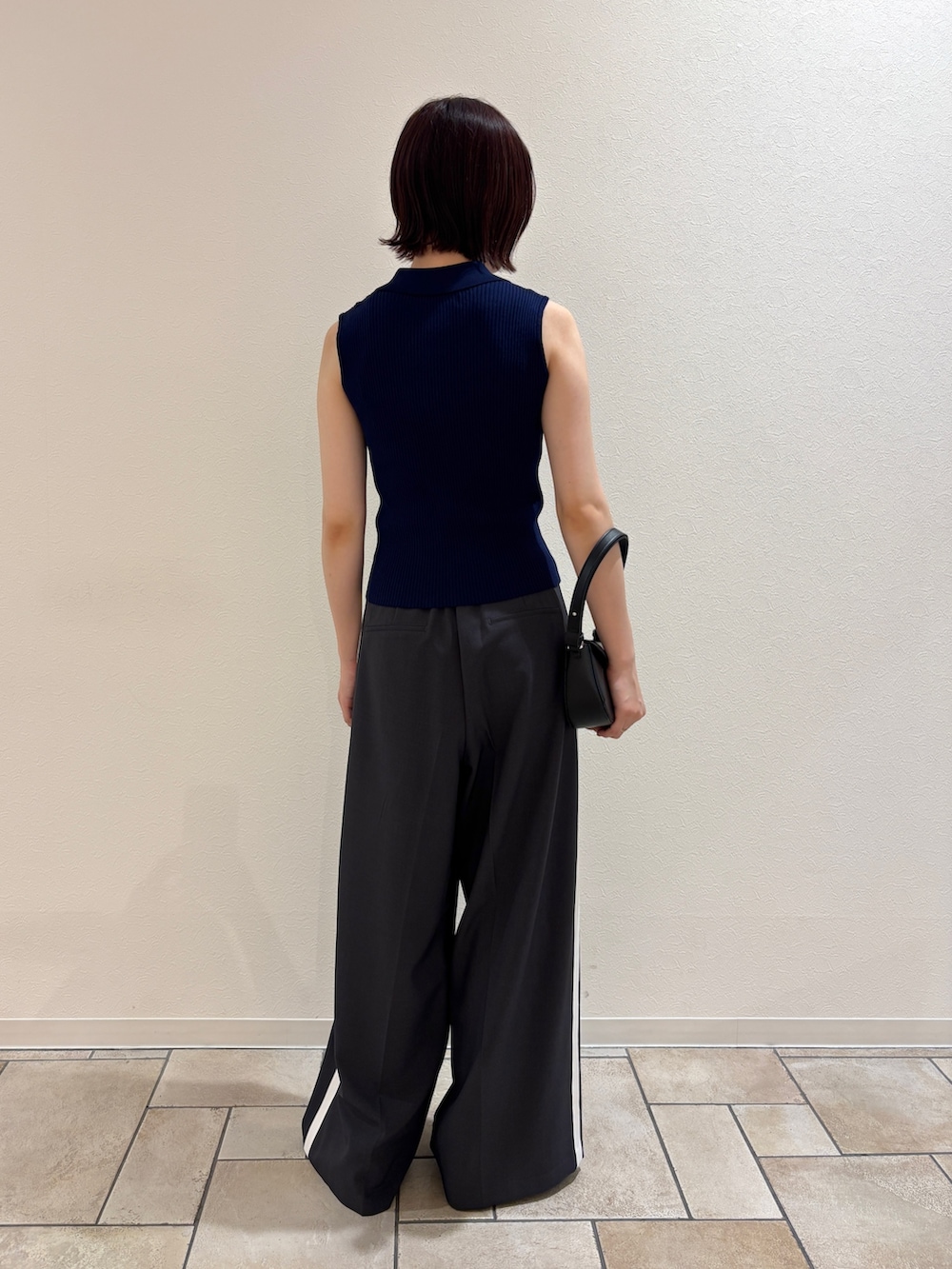 グレー系のその他パンツ、シルバー系のパンプス、ブラック系のハンドバッグを着用したレディースの夏コーディネートの3枚目の写真