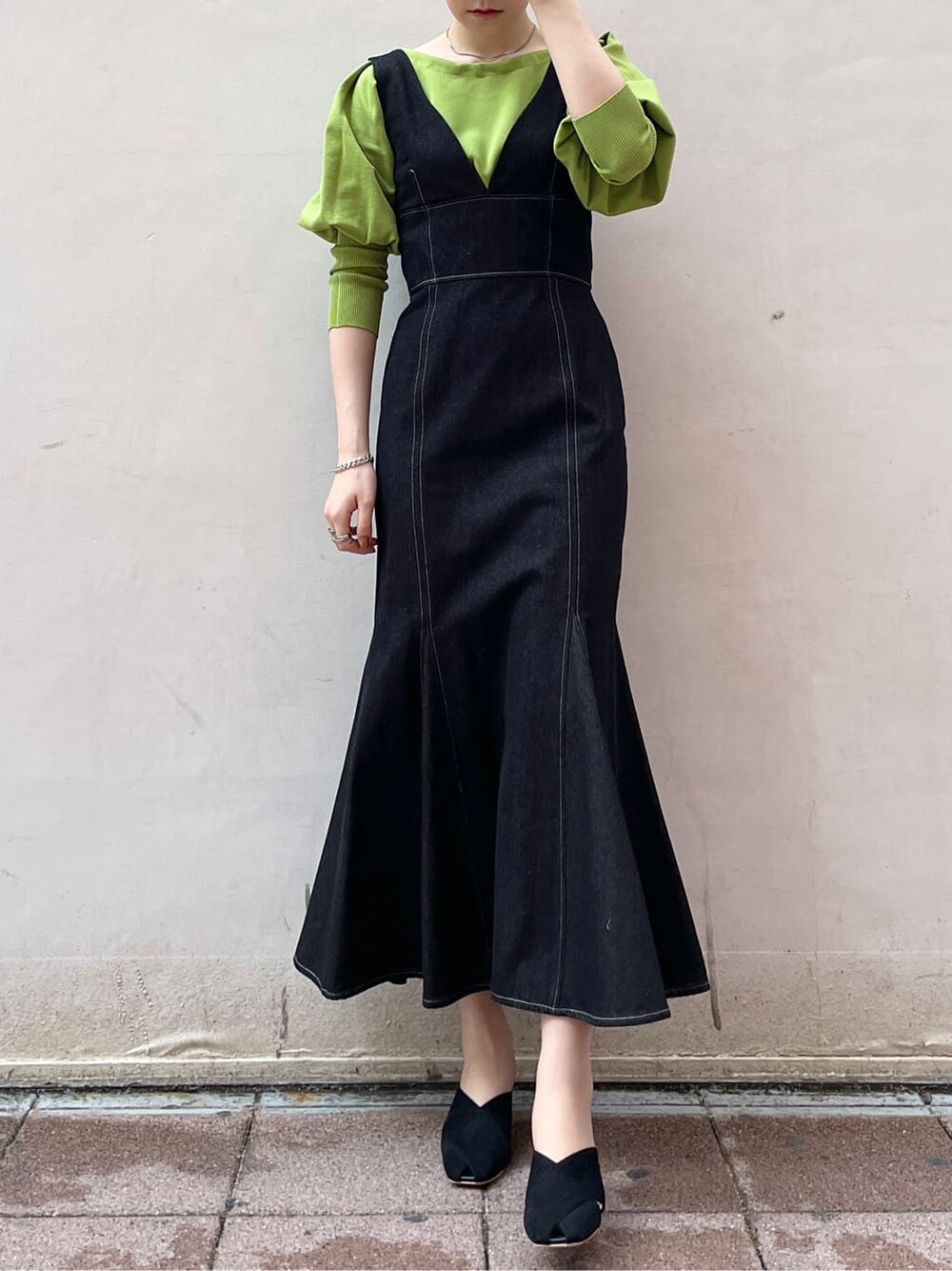 ブラック系のワンピース、グリーン系のニット/セーター、ブラック系のサンダルを着用したレディースの春コーディネートの3枚目の写真