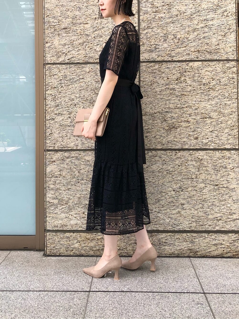 ベージュ系のパンプス、ベージュ系のクラッチバッグ、ブラック系のドレスを着用したレディースの秋コーディネートの3枚目の写真
