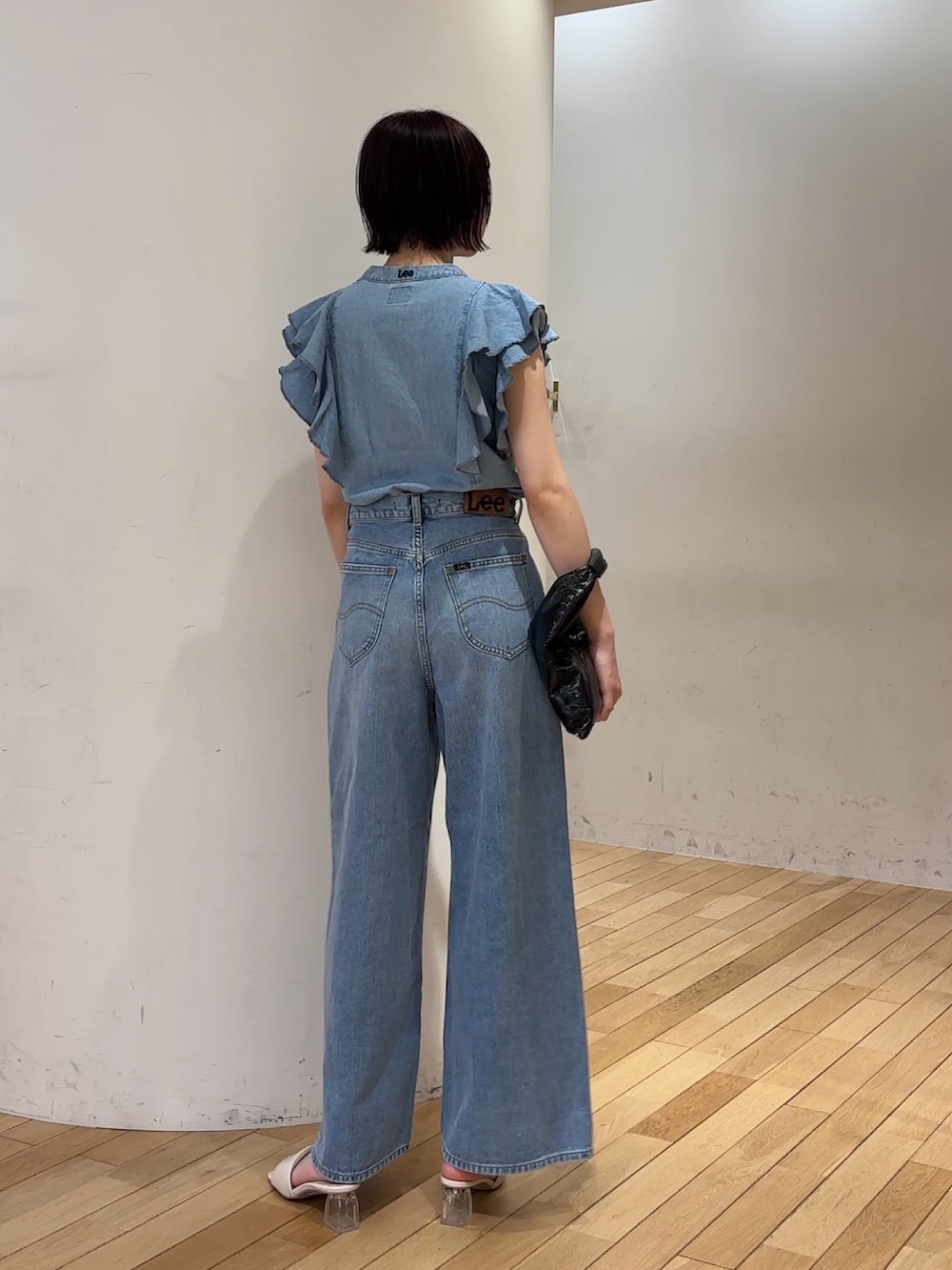 ブルー系のデニムパンツ、ブルー系のシャツ/ブラウス、ホワイト系のサンダルを着用したレディースの夏コーディネートの3枚目の写真