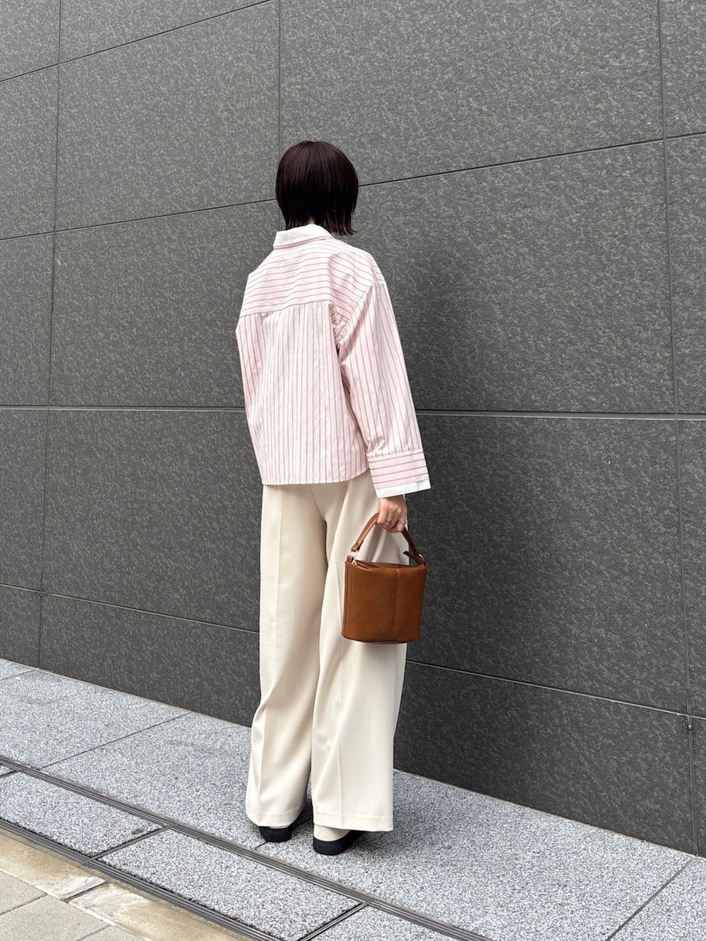 ピンク系のシャツ/ブラウス、ホワイト系のその他パンツ、イエロー系のハンドバッグを着用したレディースの春コーディネートの3枚目の写真