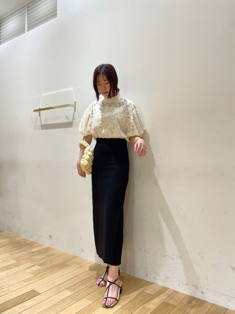 ベージュ系のハンドバッグ、ブラック系のサンダル、ホワイト系のシャツ/ブラウスを着用したレディースの夏コーディネートの3枚目の写真