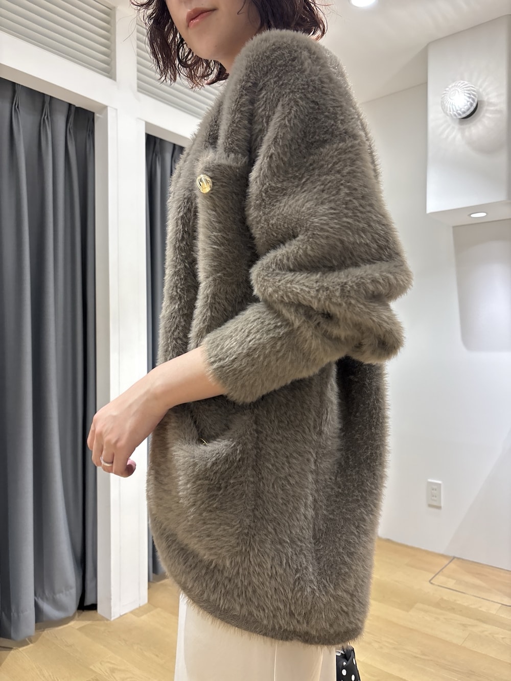 ホワイト系のスカート、ブラウン系のカーディガン/ボレロ、ホワイト系のニット/セーターを着用したレディースの秋コーディネートの6枚目の写真