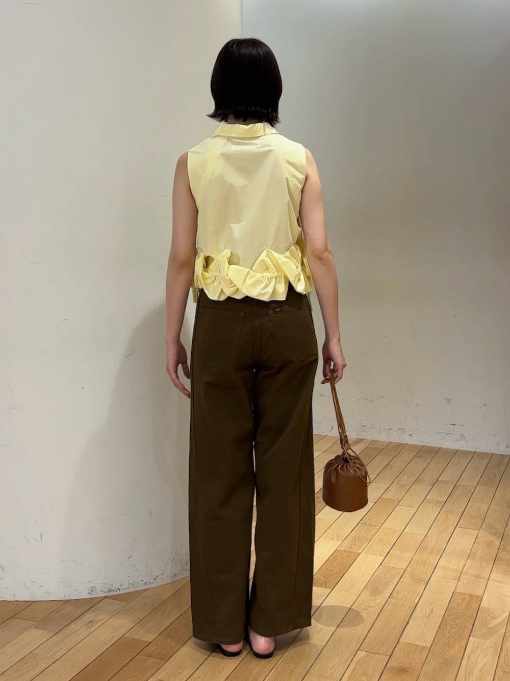 ブラウン系のデニムパンツ、イエロー系のシャツ/ブラウス、イエロー系のハンドバッグを着用したレディースの夏コーディネートの3枚目の写真