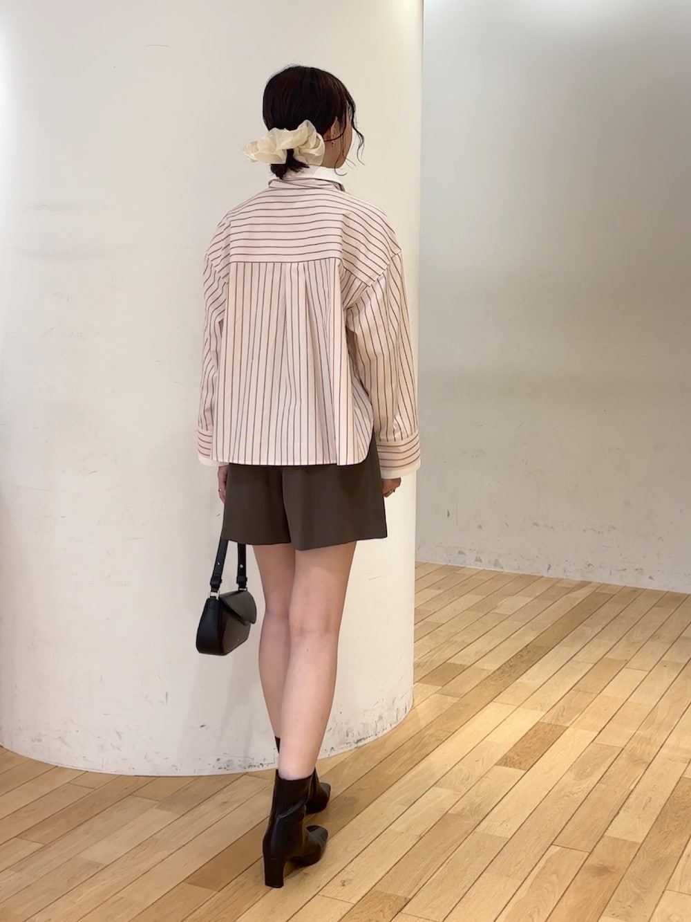 ブラウン系のその他パンツ、ブラック系のブーツ、ブラック系のハンドバッグを着用したレディースの夏コーディネートの4枚目の写真