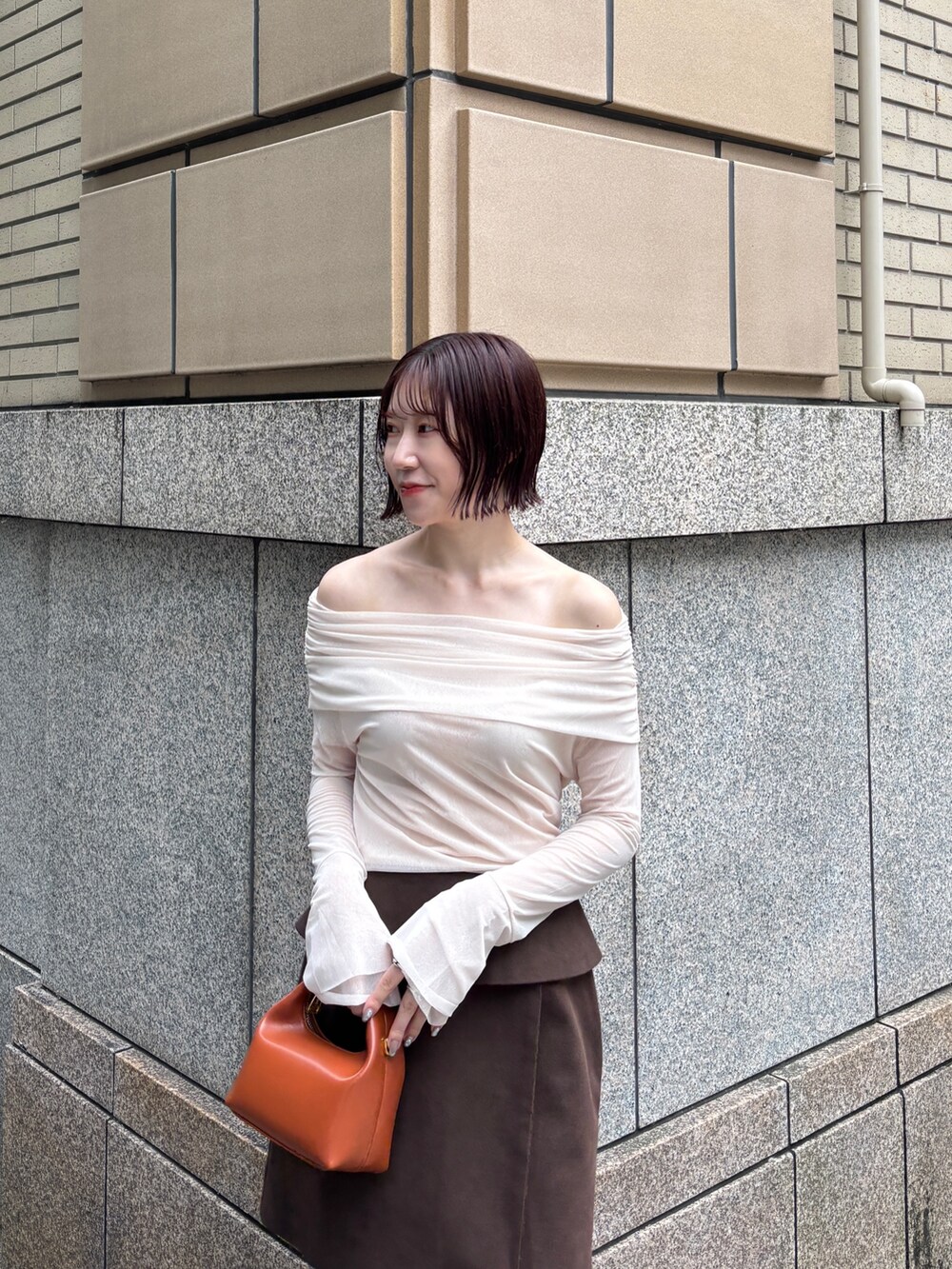 ブラウン系のブーツ、ブラウン系のハンドバッグ、ブラウン系のスカートを着用したレディースの秋コーディネートの9枚目の写真