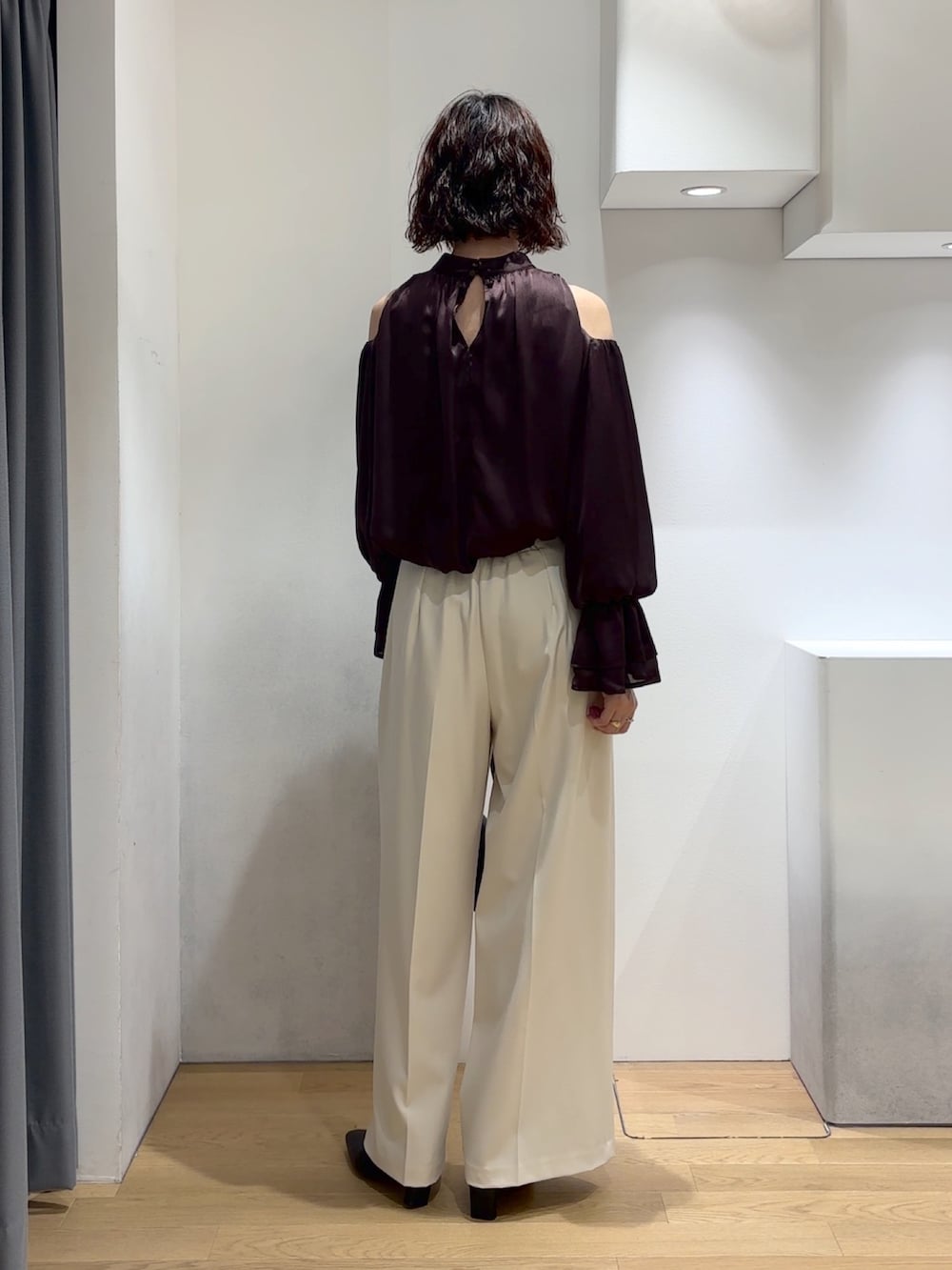 ブラウン系のシャツ/ブラウス、ホワイト系のその他パンツ、ブラック系のハンドバッグを着用したレディースの秋コーディネートの3枚目の写真