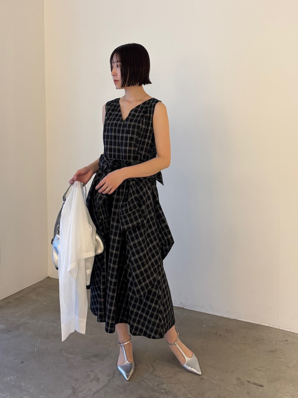 ホワイト系のカーディガン/ボレロ、シルバー系のパンプス、シルバー系のハンドバッグを着用したレディースの春コーディネートの4枚目の写真