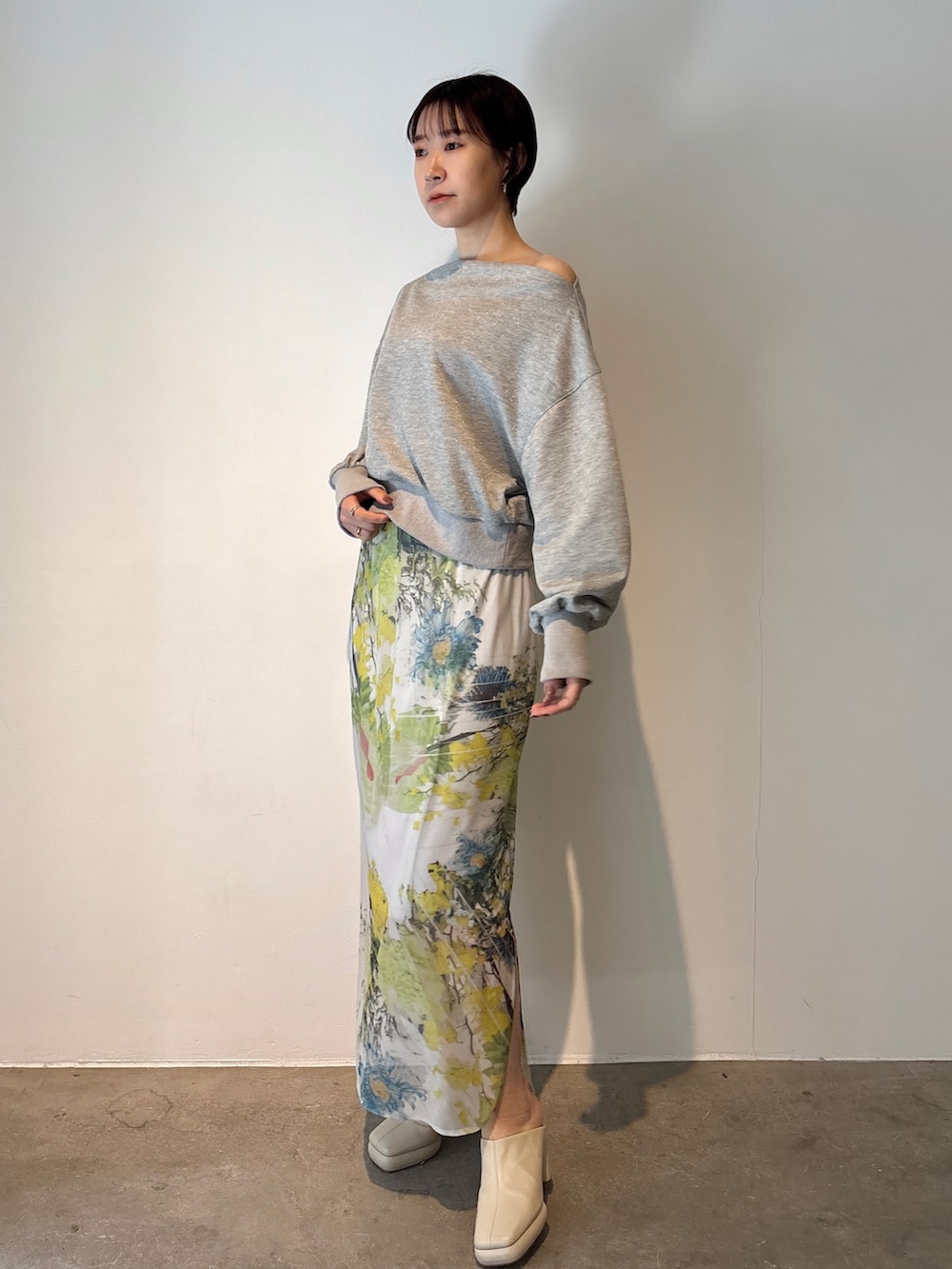 グレー系のスカート、グレー系のスウェット、ホワイト系のサンダルを着用したレディースの冬コーディネートの3枚目の写真