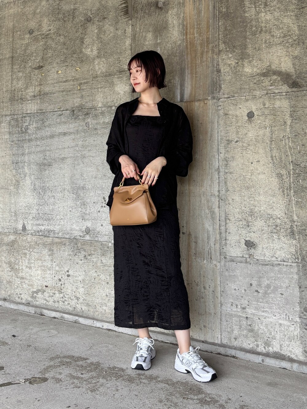 ブラック系のワンピース、ブラウン系のパンプス、ブラウン系のボストンバッグを着用したレディースの夏コーディネートの7枚目の写真