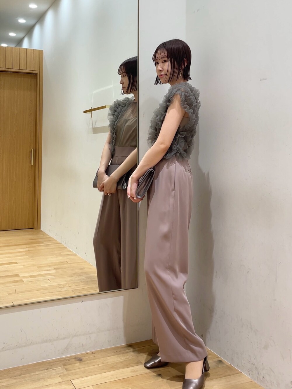 シルバー系のハンドバッグ、ピンク系のパンツドレス、その他のパンプスを着用したレディースの冬コーディネートの4枚目の写真