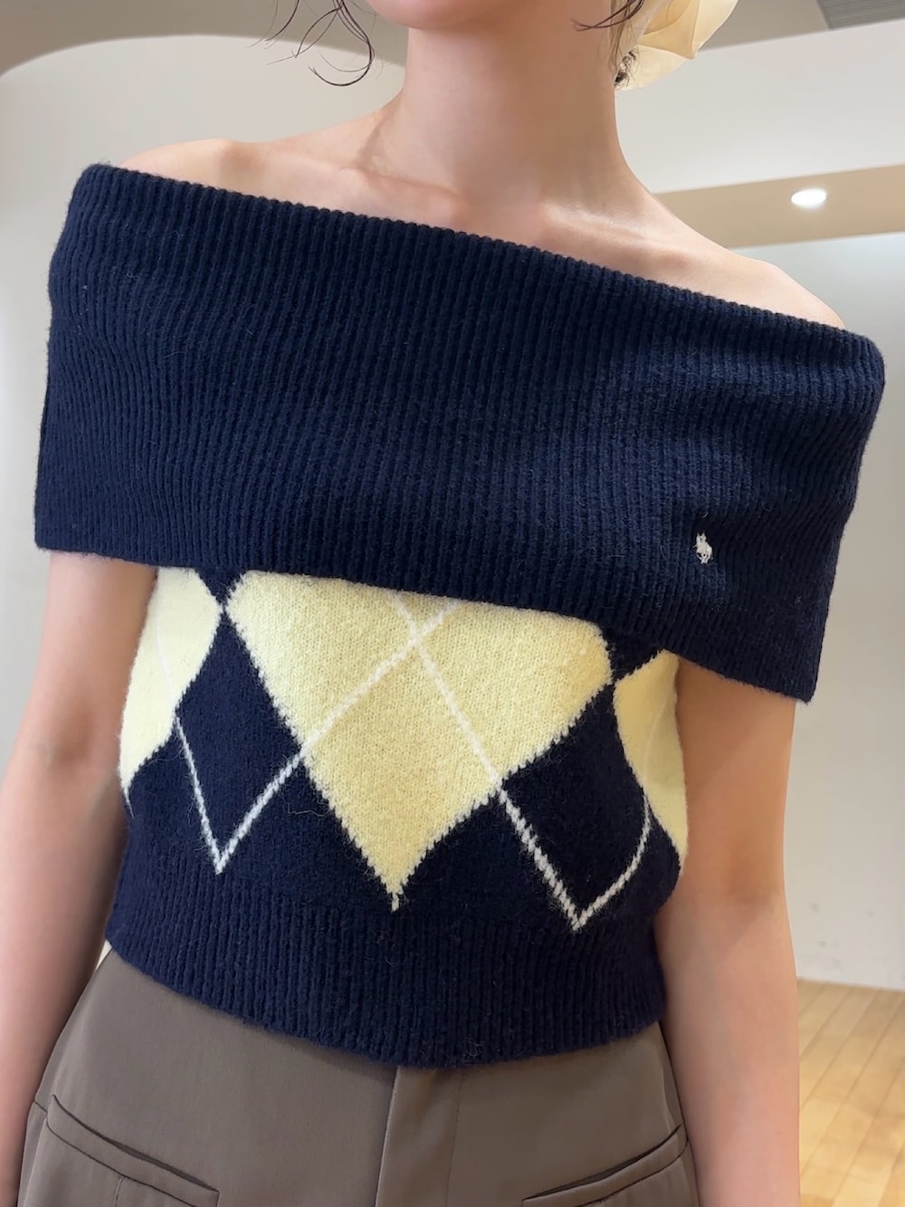 ブラウン系のその他パンツ、ブルー系のニット/セーター、ブラック系のハンドバッグを着用したレディースの夏コーディネートの8枚目の写真