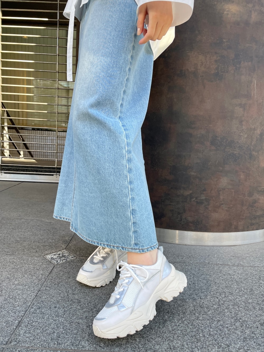 ホワイト系のシャツ/ブラウス、グリーン系のデニムスカート、ホワイト系のスニーカーを着用したレディースの春コーディネートの9枚目の写真