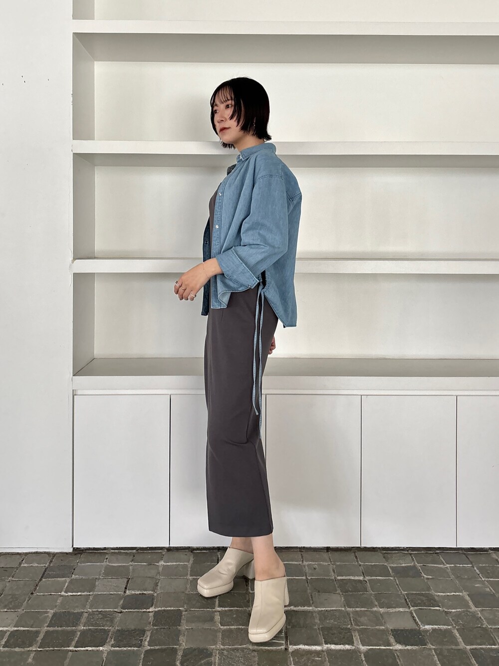 グレー系のワンピース、ホワイト系のサンダル、ブルー系のシャツ/ブラウスを着用したレディースの冬コーディネートの3枚目の写真