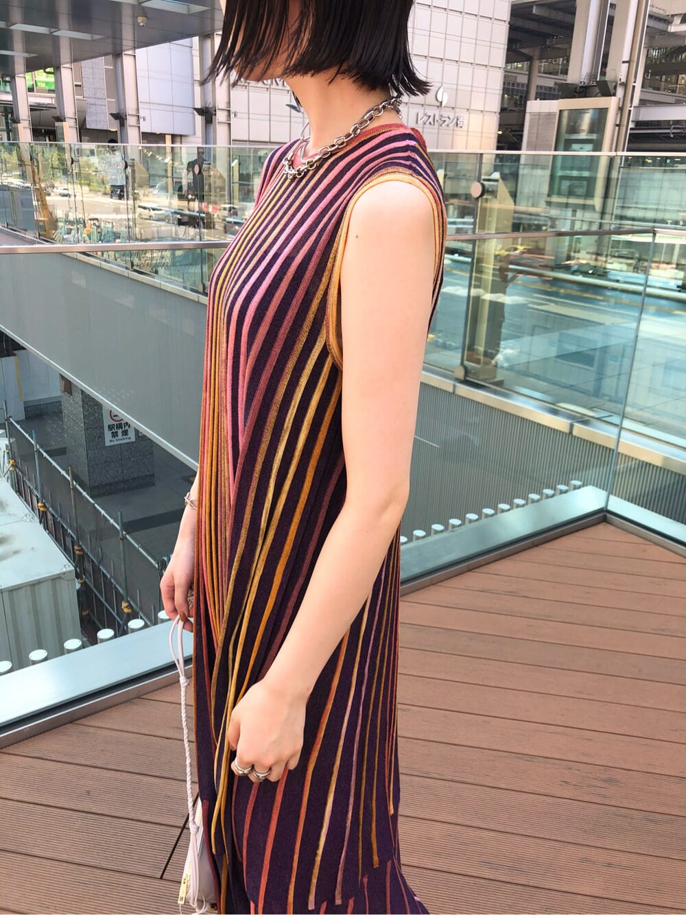 ホワイト系のショルダーバッグ、パープル系のワンピース、ブラウン系のサンダルを着用したレディースの夏コーディネートの5枚目の写真