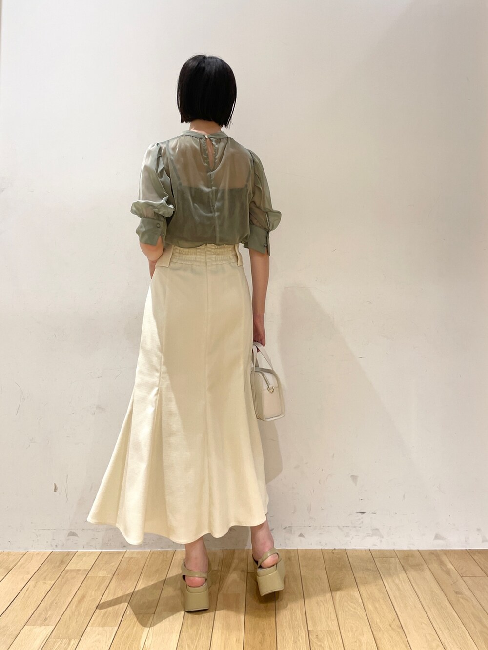 グリーン系のシャツ/ブラウス、ホワイト系のスカート、ホワイト系のショルダーバッグを着用したレディースの夏コーディネートの4枚目の写真