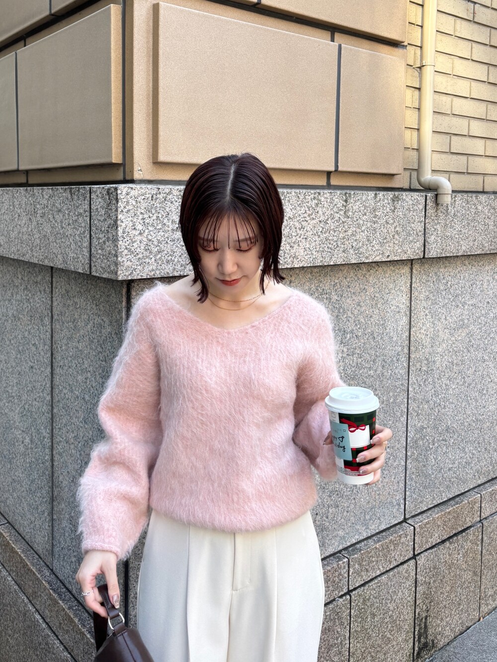 ピンク系のニット/セーター、ブラウン系のハンドバッグ、ホワイト系のその他パンツを着用したレディースの秋コーディネートの4枚目の写真