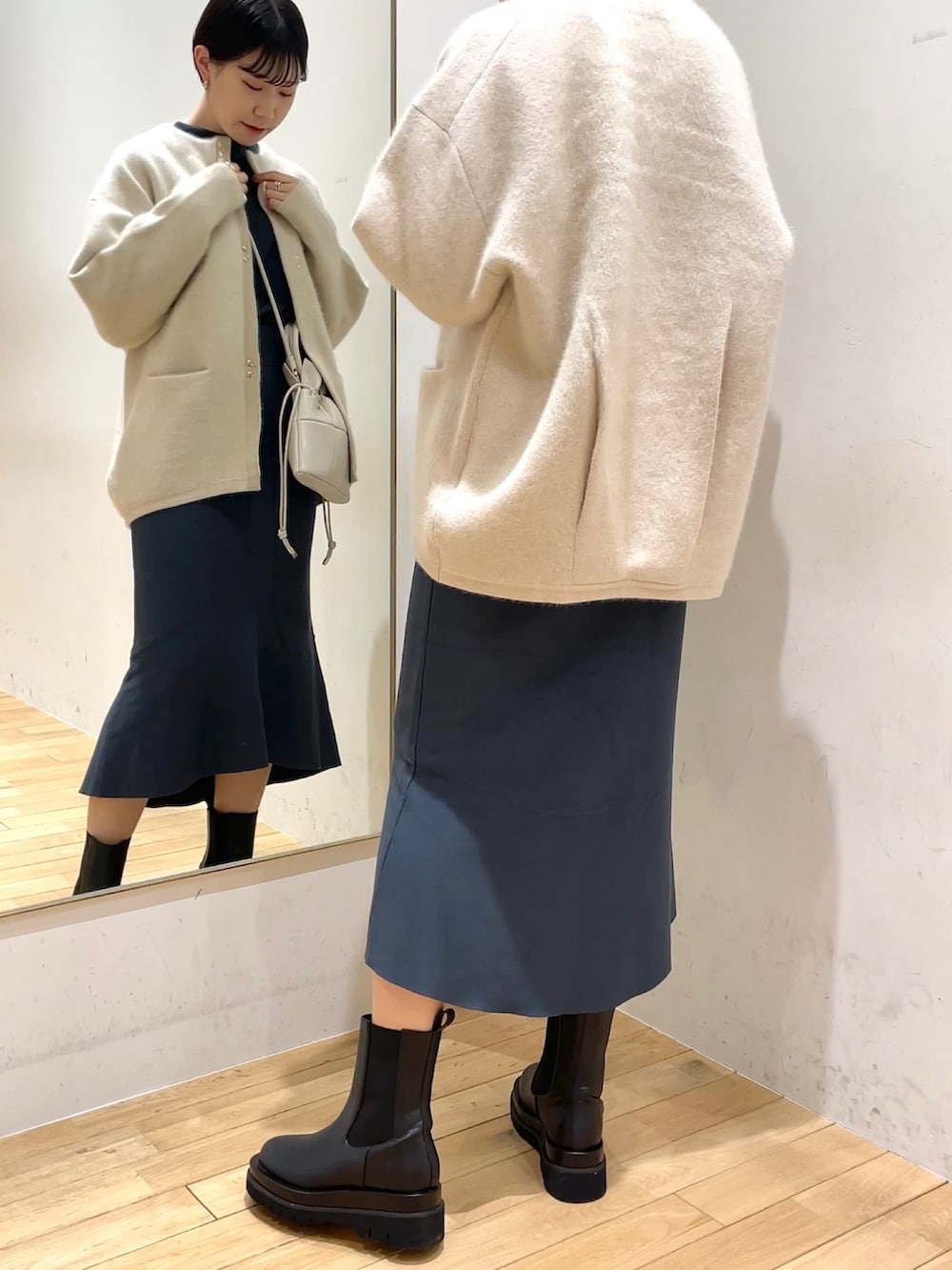 ホワイト系のカーディガン/ボレロ、グリーン系のスカート、グリーン系のニット/セーターを着用したレディースの冬コーディネートの2枚目の写真